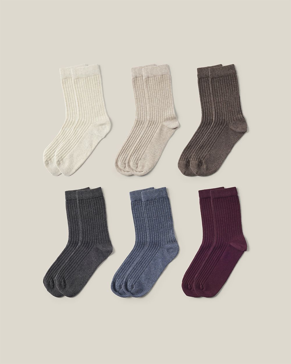 Sex par ribbstickade strumpor i mjuka, jordnära färger som beige, brun, grå, blå och vinröd.