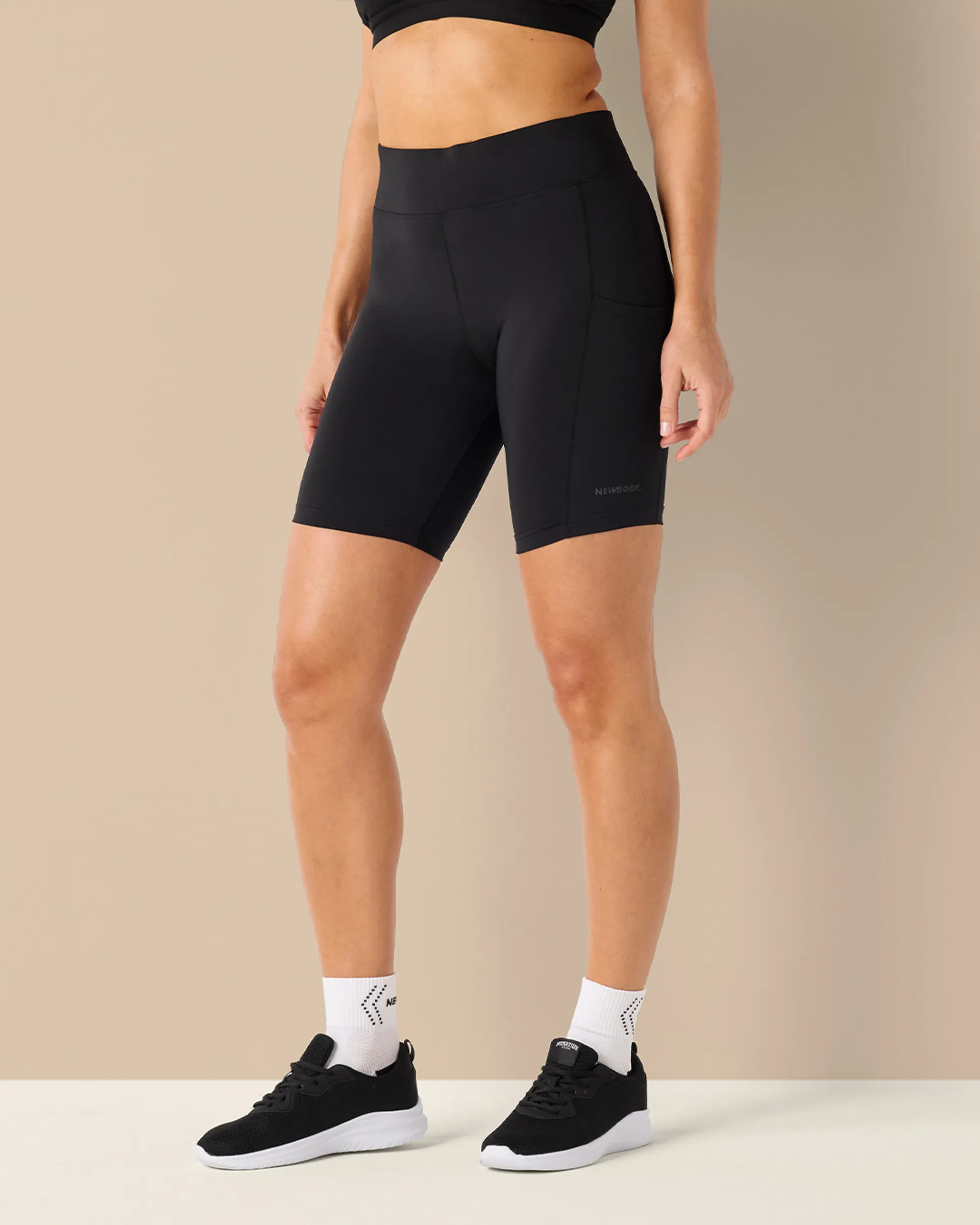 Svarta short tights med smal passform och hög midja, designade för rörelse och komfort. Materialet är mjukt och stretchigt med praktiska sidofickor.