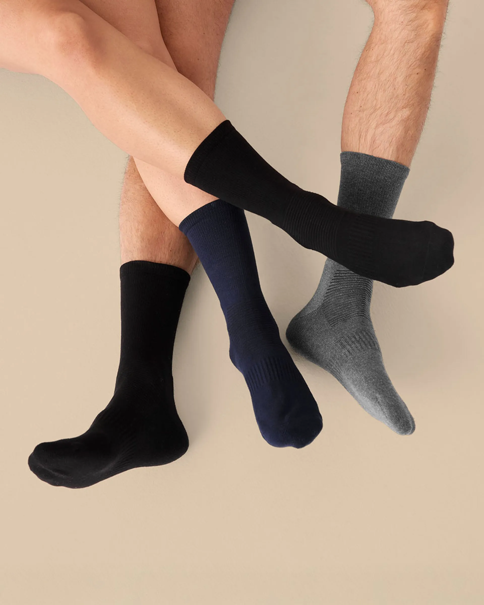 Eco Comfort Socks Premium-strumpor i olika färger burna av man och kvinna sittande på golvet.