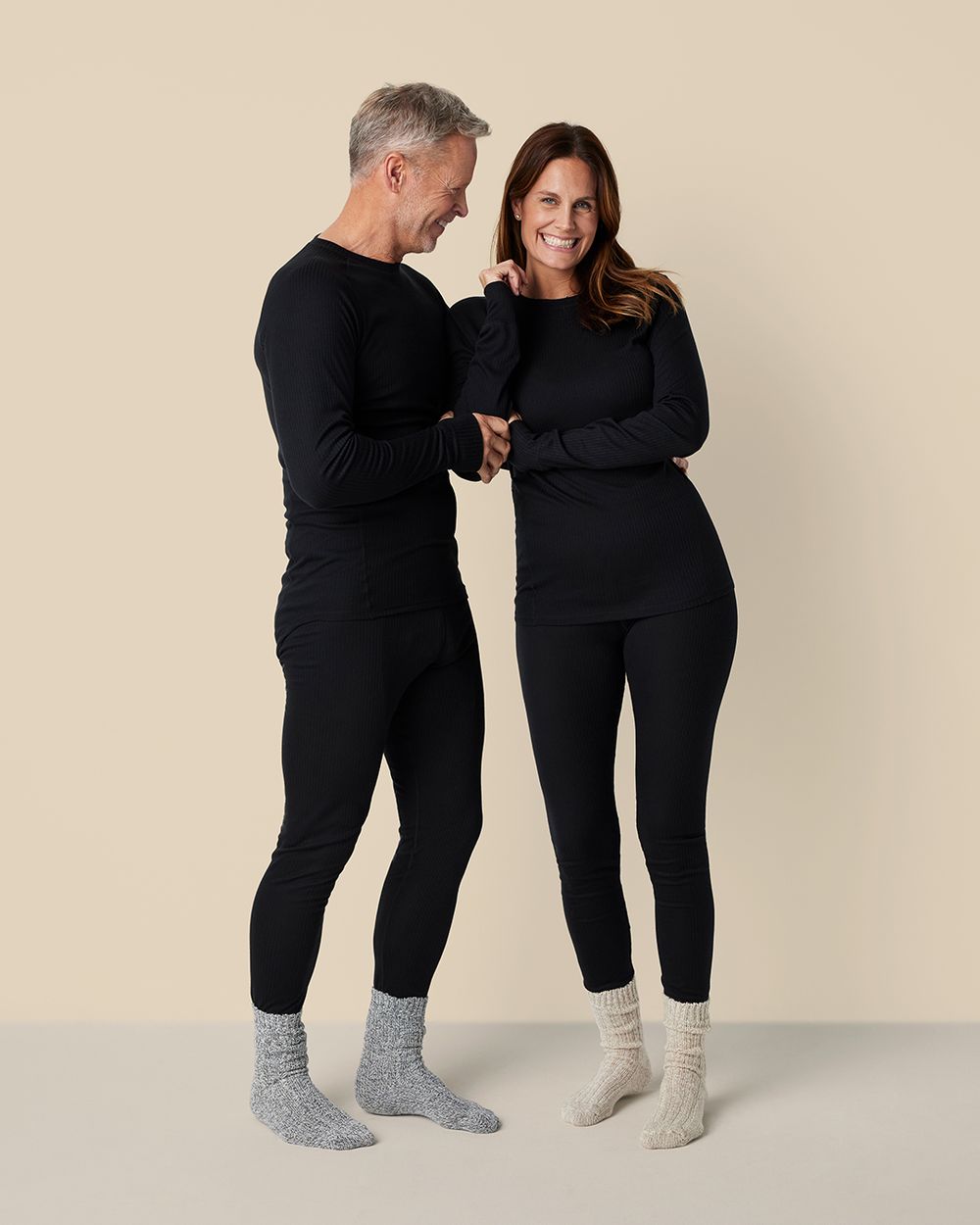 Ett unisex set med långärmad tröja och tights i svart, parat med varsin mysig, tjockstickad socka i grått och beige.