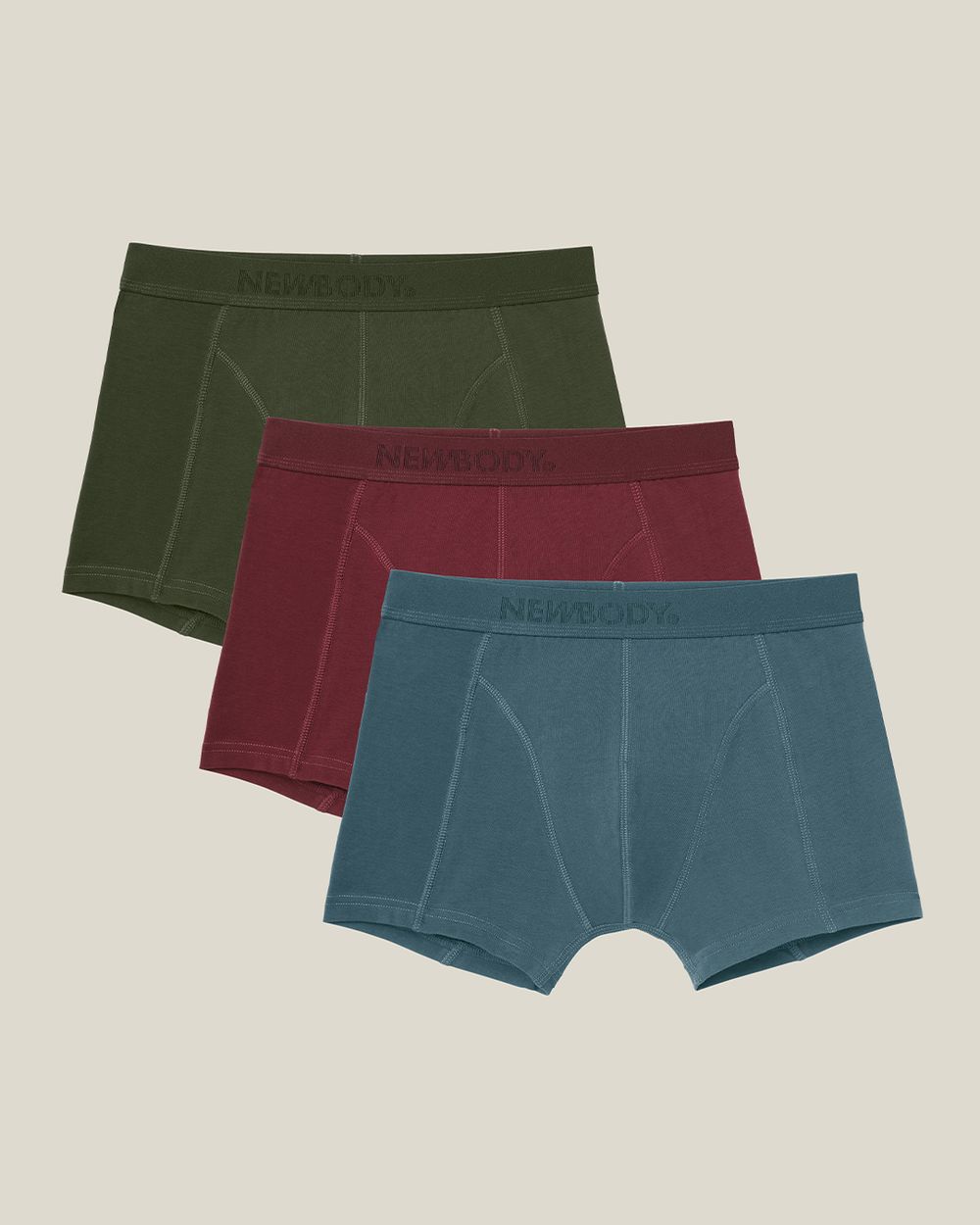 Tre par boxershorts i lugna, naturliga färger som mörkgrönt, vinrött och blågrått med diskret logga på midjebandet.