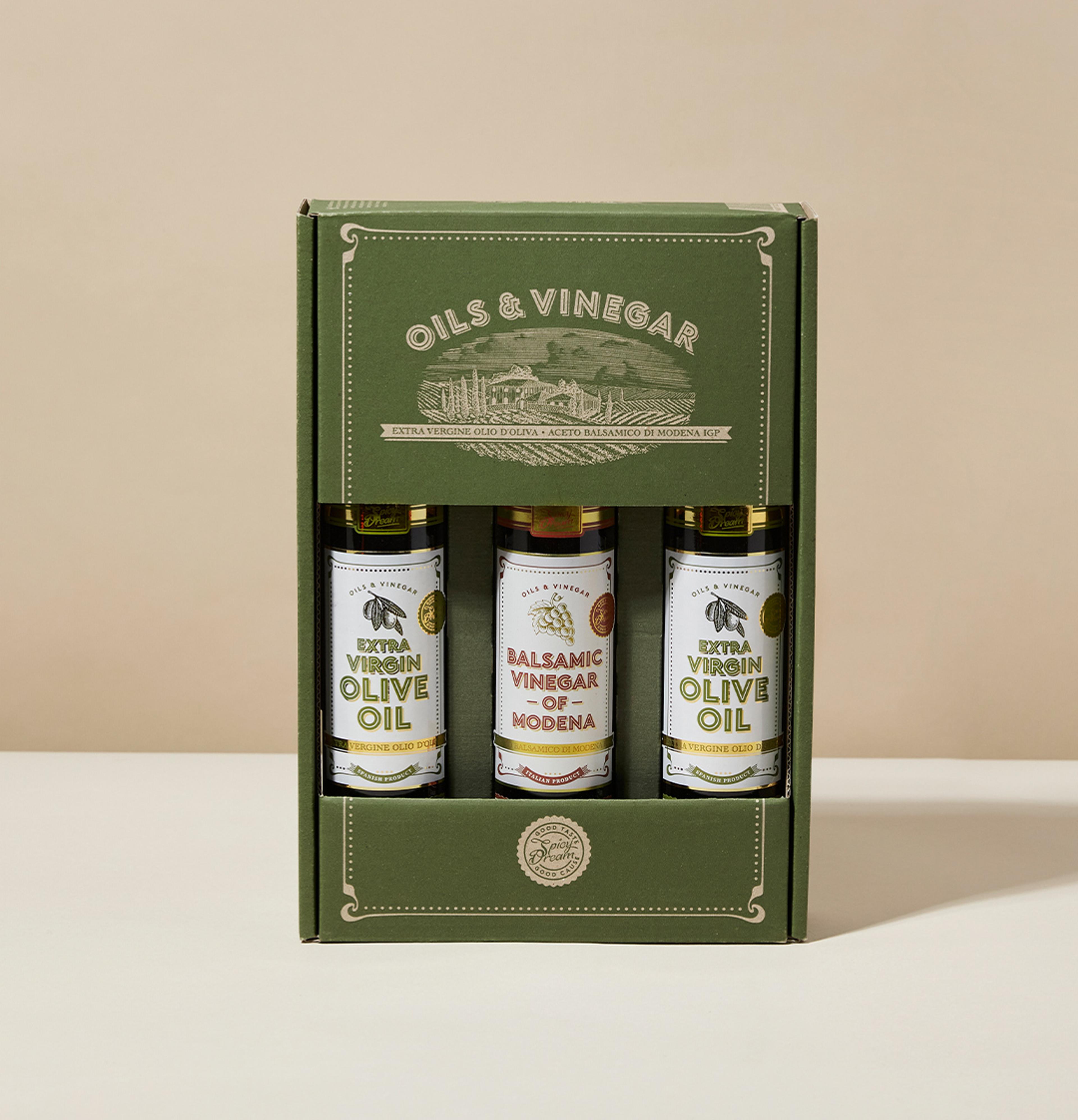 En kartong med tre flaskor innehållande extra virgin olivolja och balsamvinäger från Modena, med en grön och stilren förpackning. Flaskorna står prydligt uppradade och visar etiketterna tydligt.