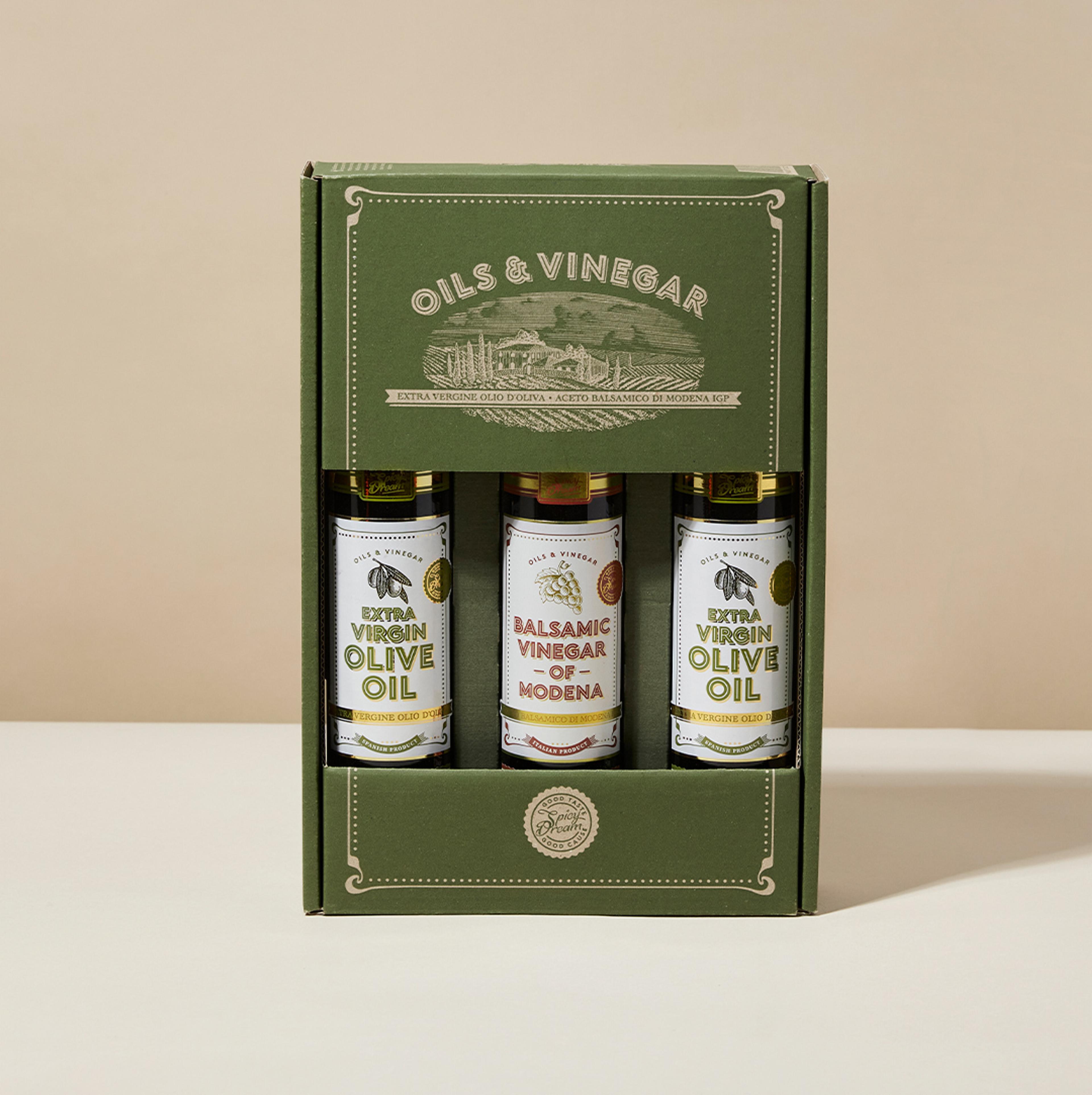 En kartong med tre flaskor innehållande extra virgin olivolja och balsamvinäger från Modena, med en grön och stilren förpackning. Flaskorna står prydligt uppradade och visar etiketterna tydligt.