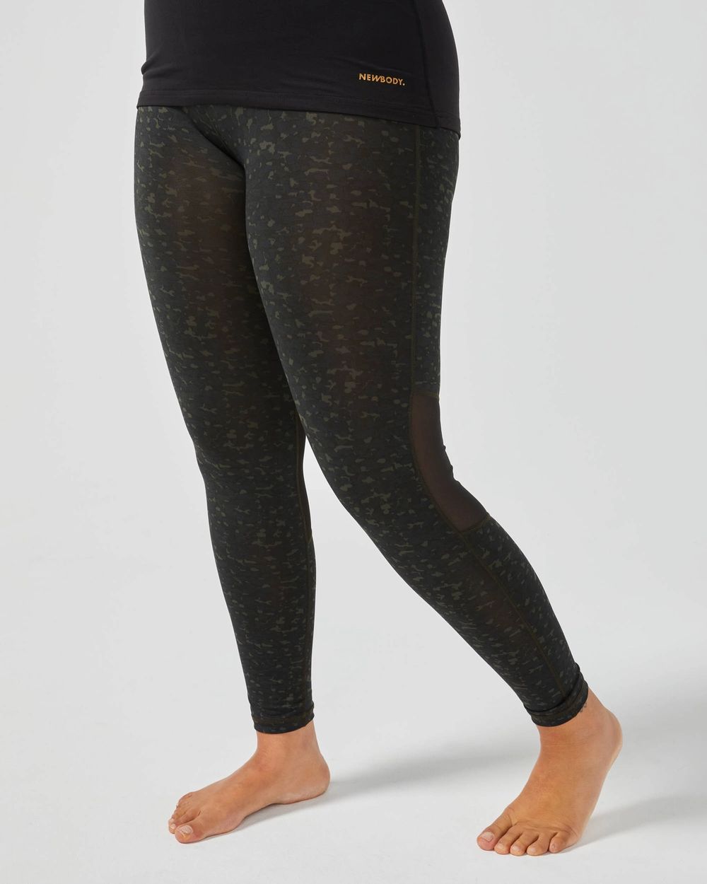 Mörkgröna tights med diskret camouflage-mönster och detaljer av mesh på benen. Tight och följsam passform, perfekt för träning eller vardagsbruk.