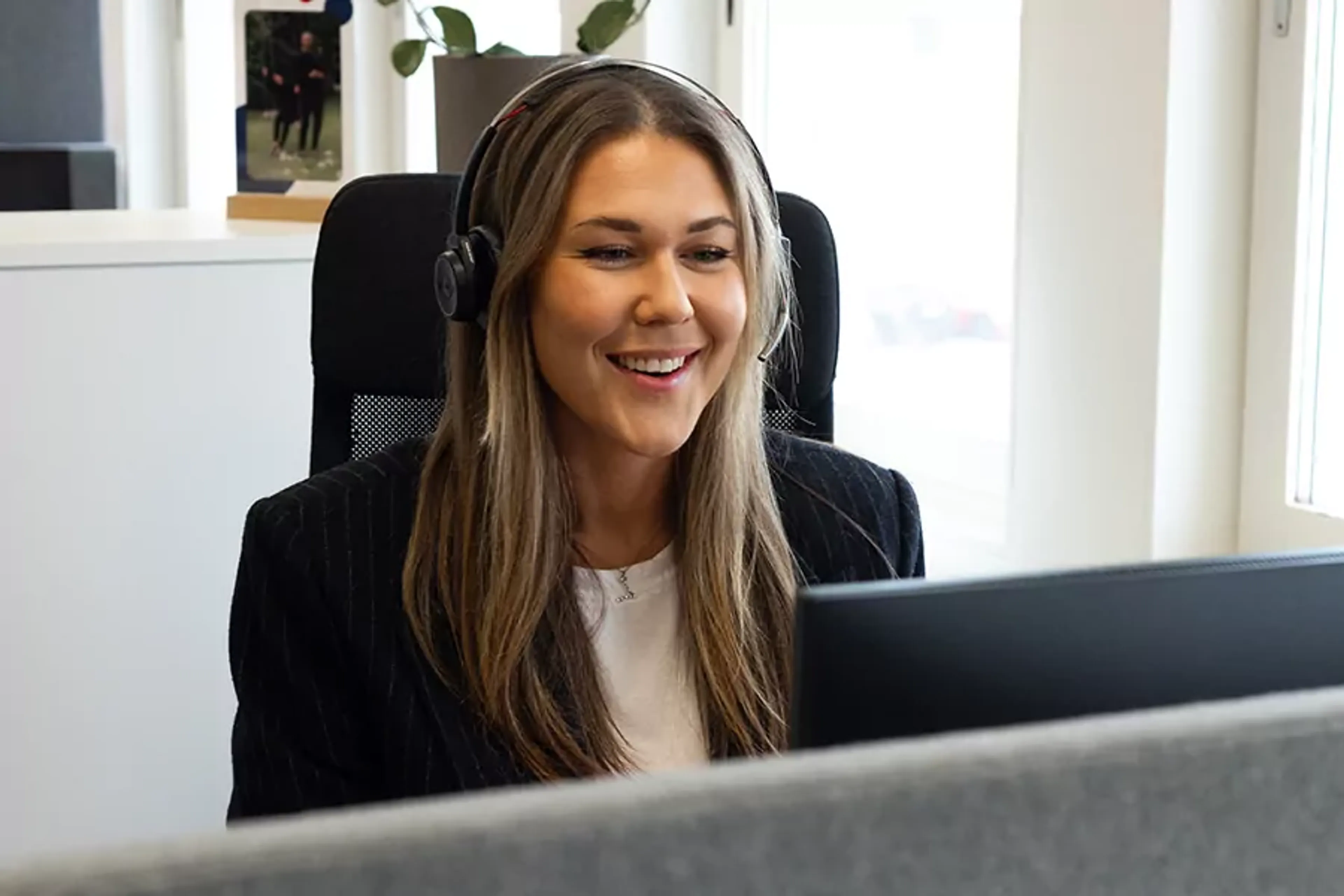 Kvinnlig kollega som sitter i samtal med kund över telefon