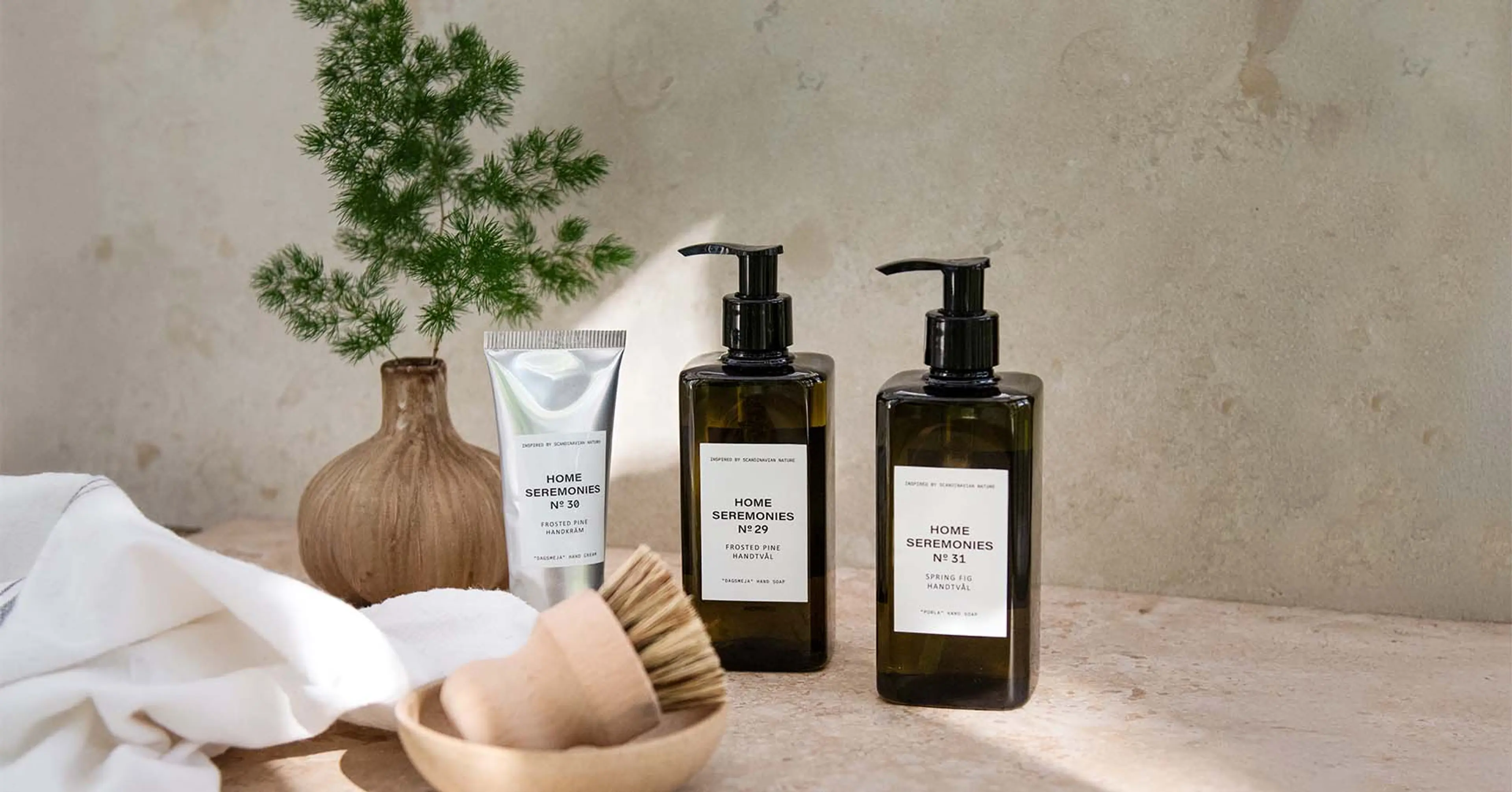 Två flaskor med handtvål och en tub handkräm i en inspirerande miljö
