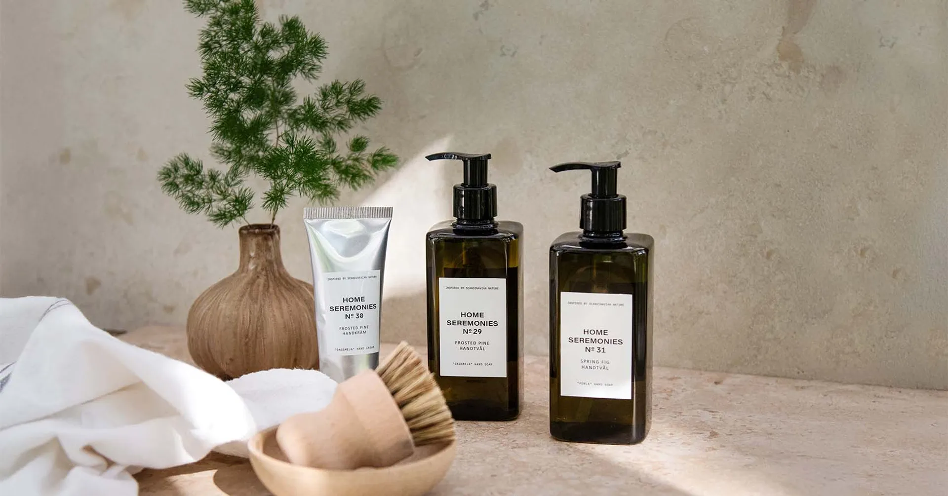 Två flaskor med handtvål och en tub handkräm i en inspirerande miljö