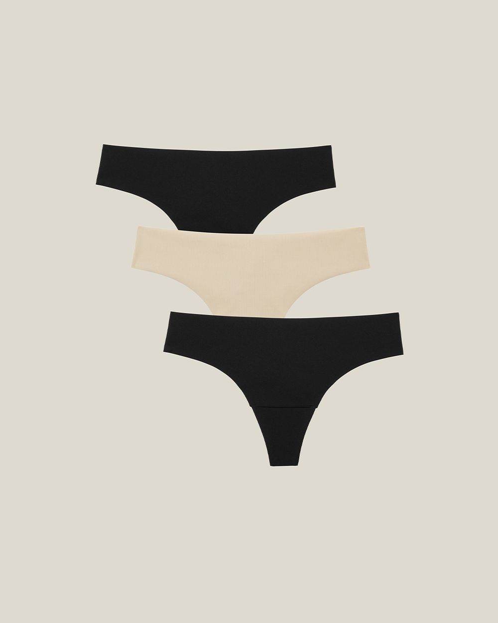 Tre sömlösa trosor i neutral beige och svart, designade för att vara osynliga under kläder. Mjukt, stretchigt material som sitter bekvämt hela dagen.