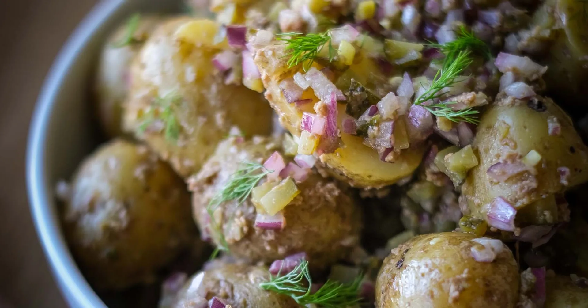 Potatissallad med små, skalade delikatesspotatisar blandade med finhackad rödlök och dill. En enkel och fräsch sommarrätt.