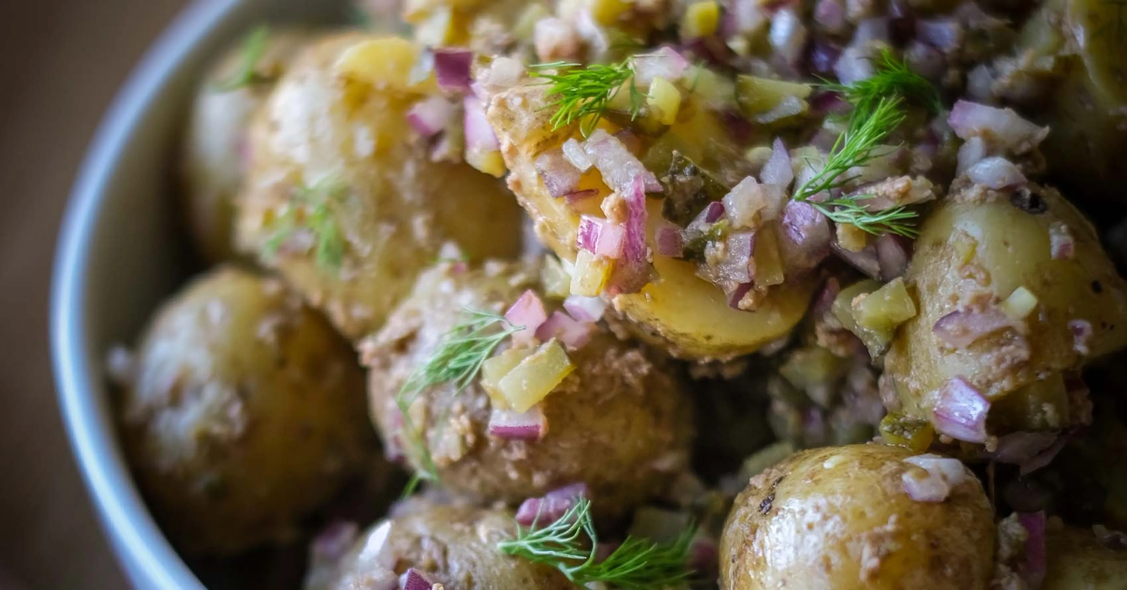 Potatissallad med små, skalade delikatesspotatisar blandade med finhackad rödlök och dill. En enkel och fräsch sommarrätt.
