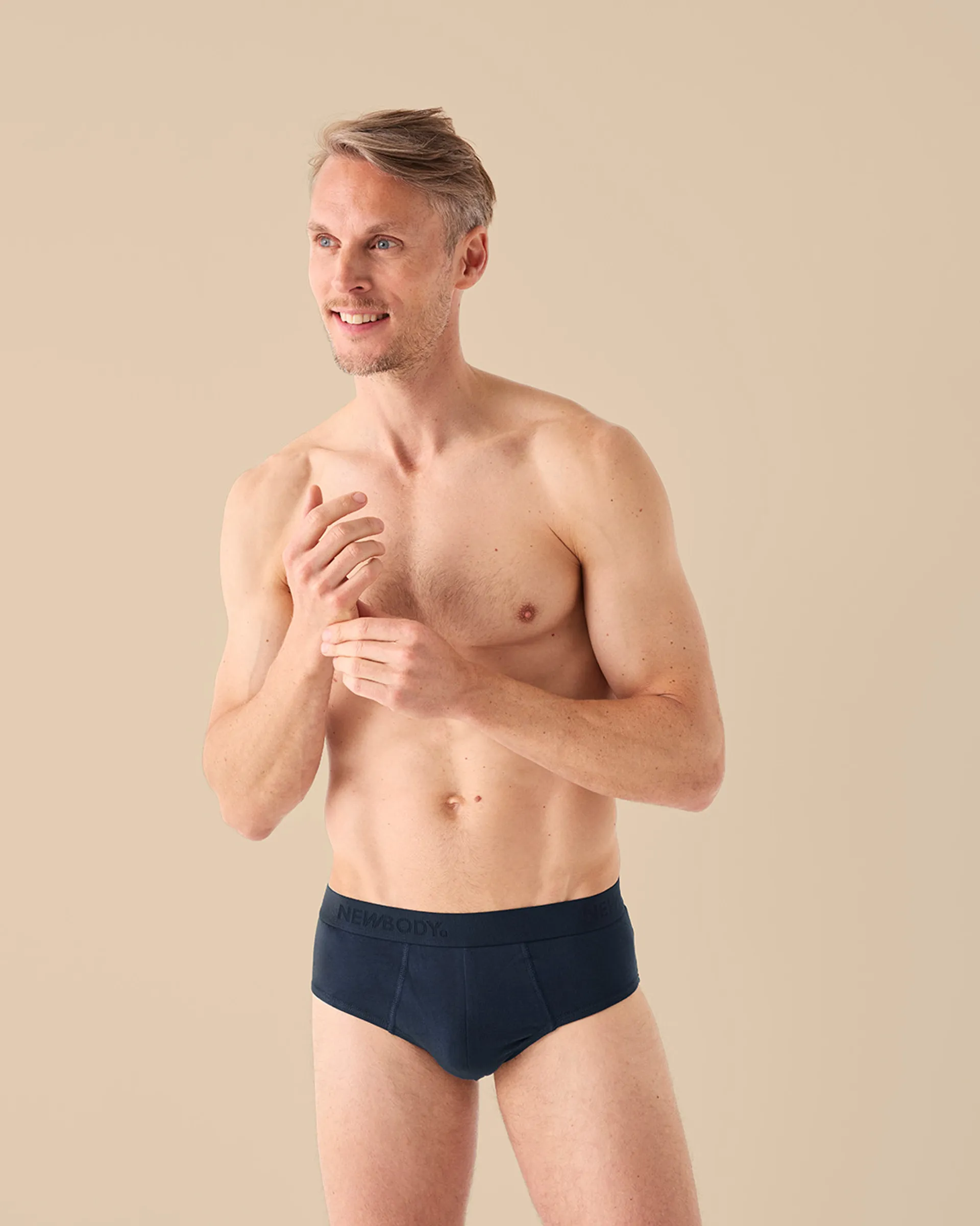 Manlig modell som bär mörkblå kalsonger i klassisk briefmodell, visade framifrån.