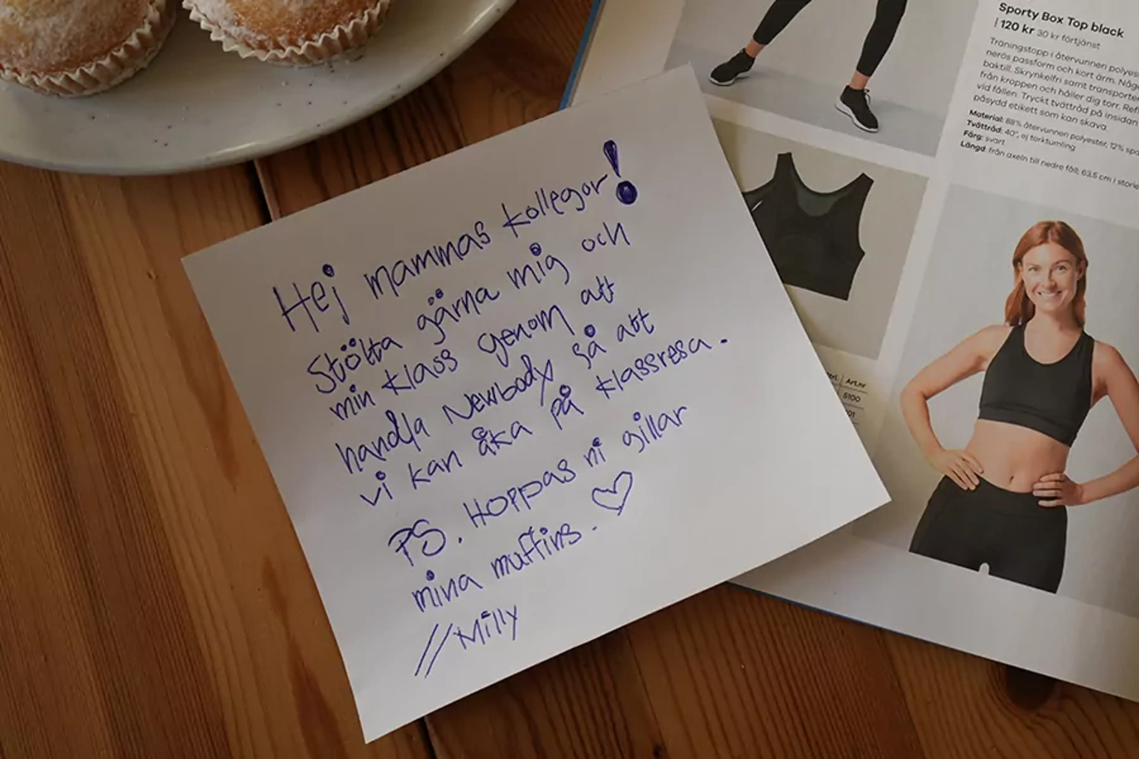 Handskriven lapp med uppmaning att stötta en skolklass genom att handla ur en katalog som visar sportiga kläder, bredvid ett fat med muffins.