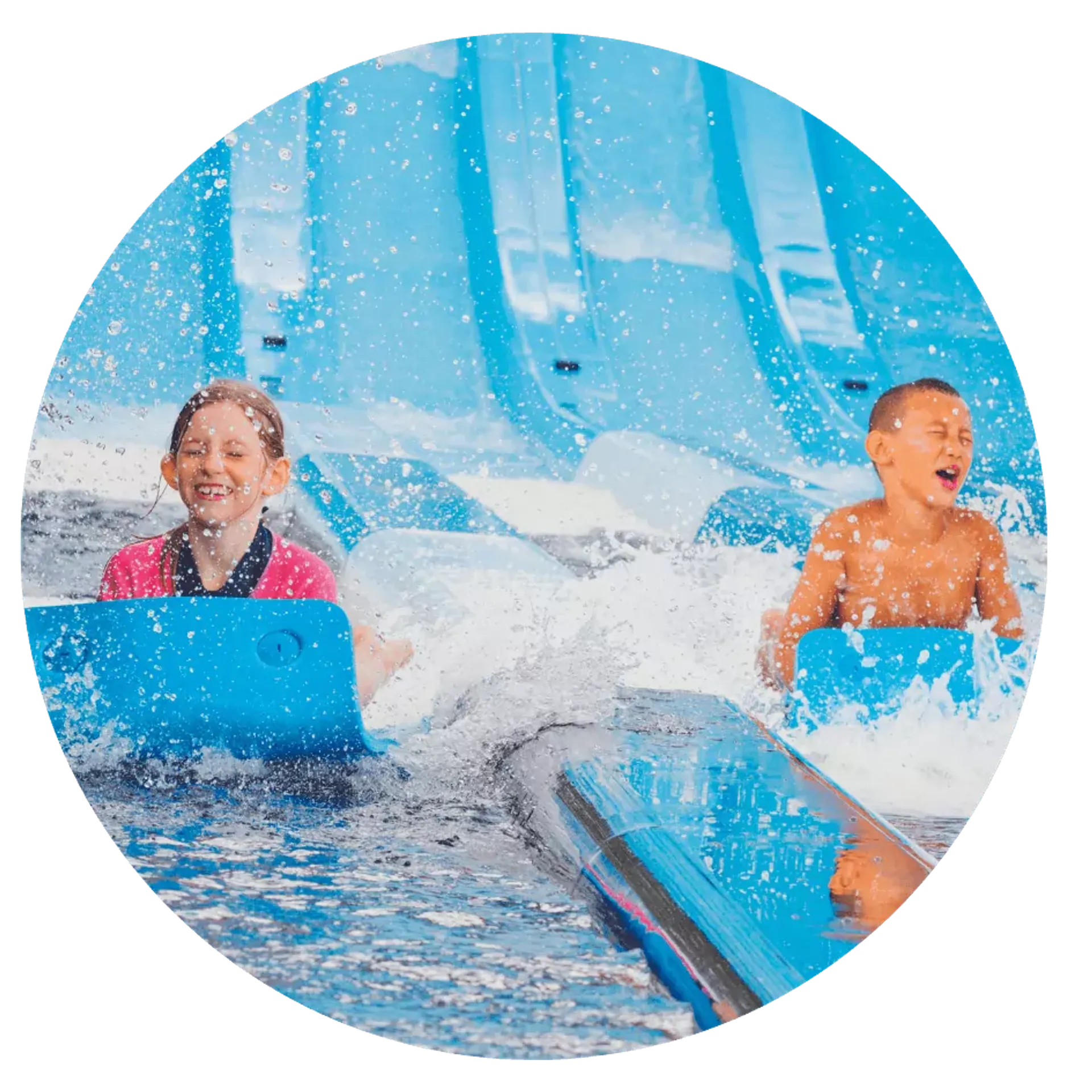Två barn åker bredvid varandra på blå vattenrutschkanor och plaskar i vattnet. Bakgrunden visar flera ljusblå rutschkanor vid en vattenpark.