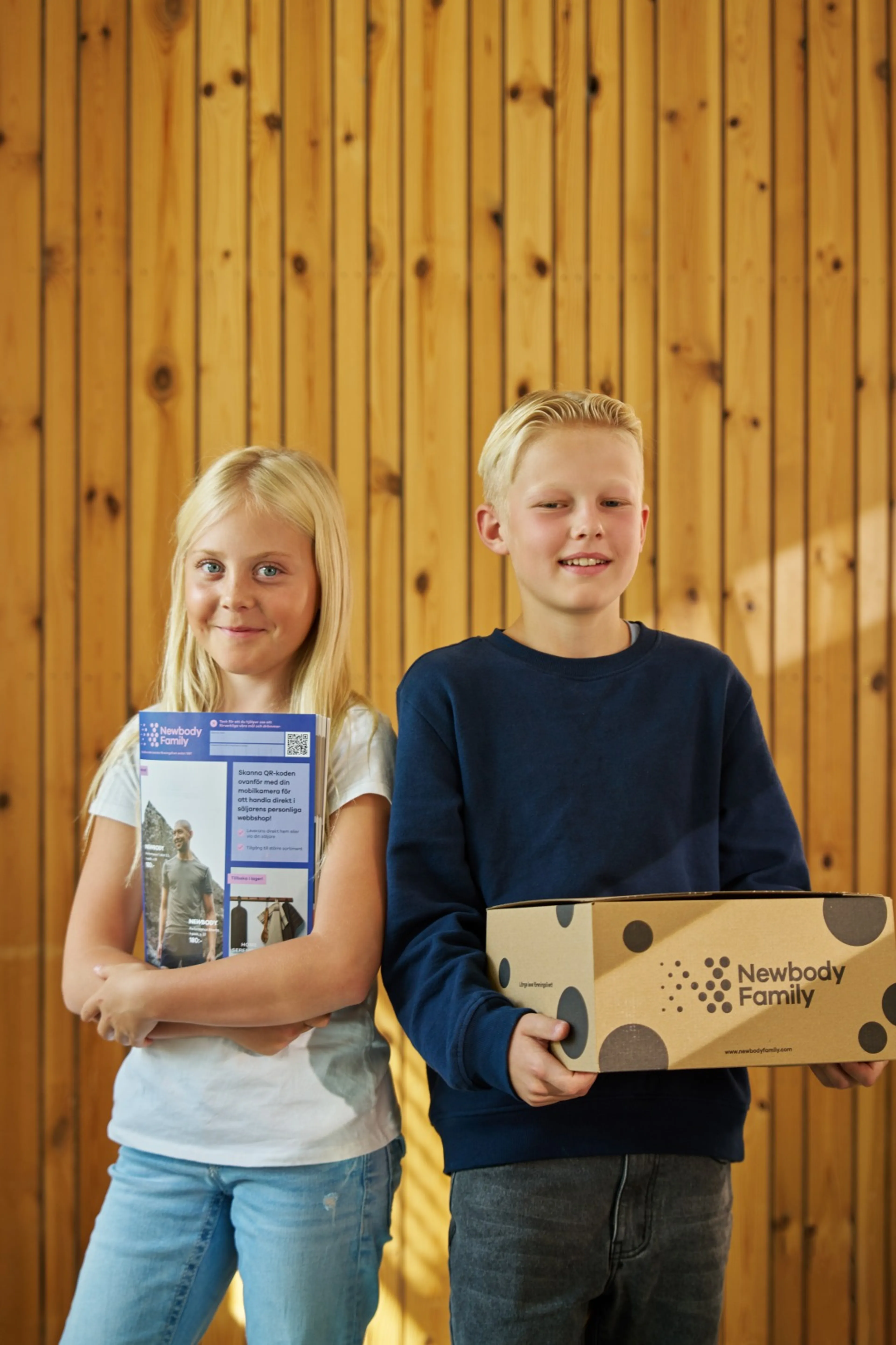 Tjej och kille som håller i newbody kartong och katalog