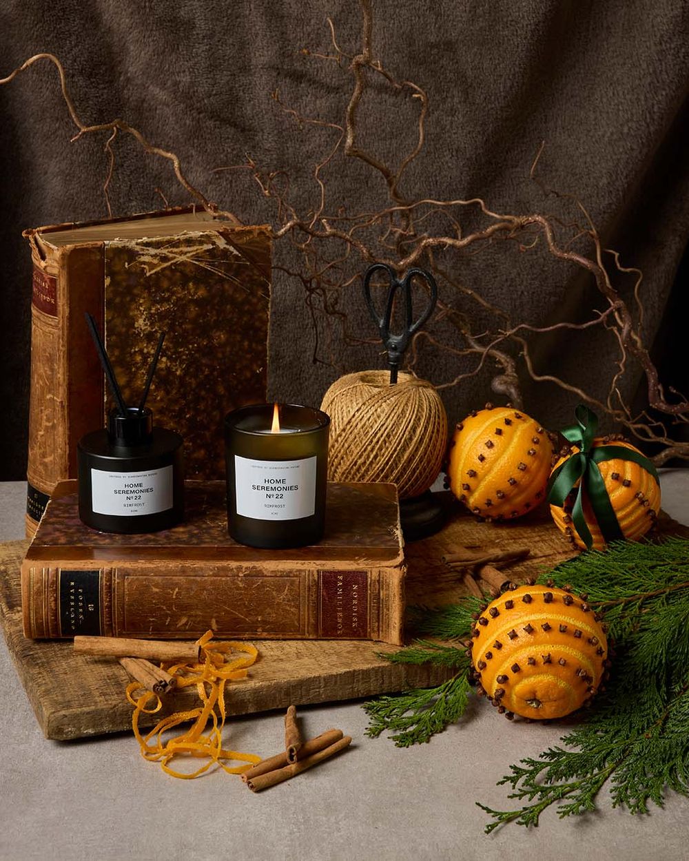 Aroma Set beståendes av doftljus och diffuser, stylat i miljö med apelsin och nejlika som representerar doften