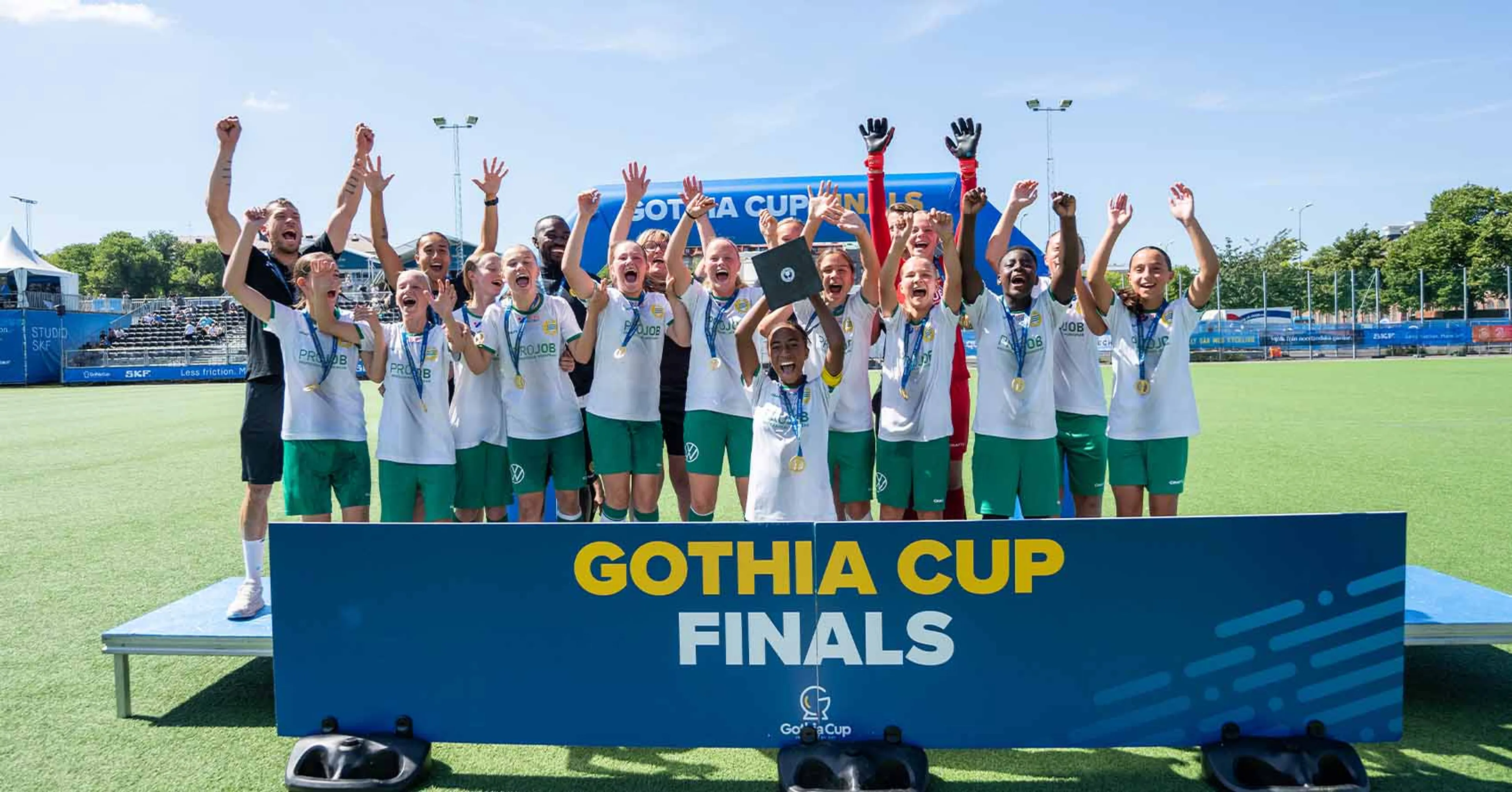 Ett fotbollslag med tjejer som håller upp ett pris i gothia cup