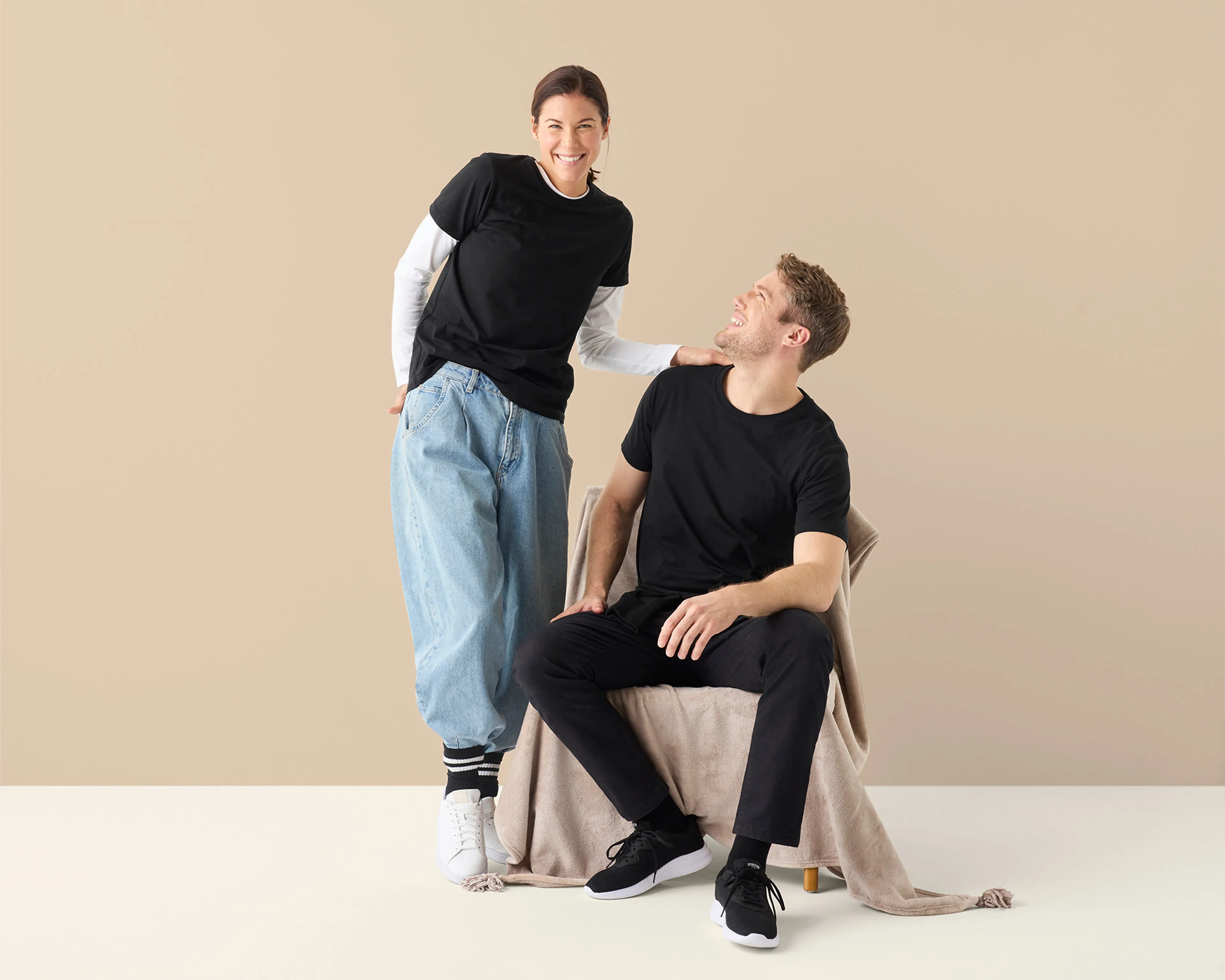 Svart t-shirt i mjuk bomull, bärs av kvinna och man i avslappnad passform med rund halsringning.