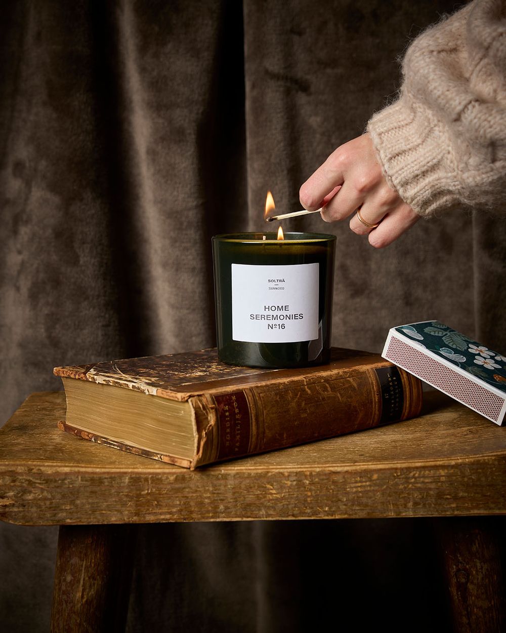 Stort doftljus Solträ med två vekar, visad när det tänds av kvinna.