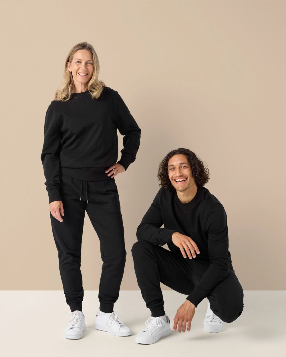 Svart sweatshirt och matchande mjukisbyxor i en enkel, bekväm design för dam och herr. Mjuka ribbade muddar och rund halsringning ger en avslappnad look.