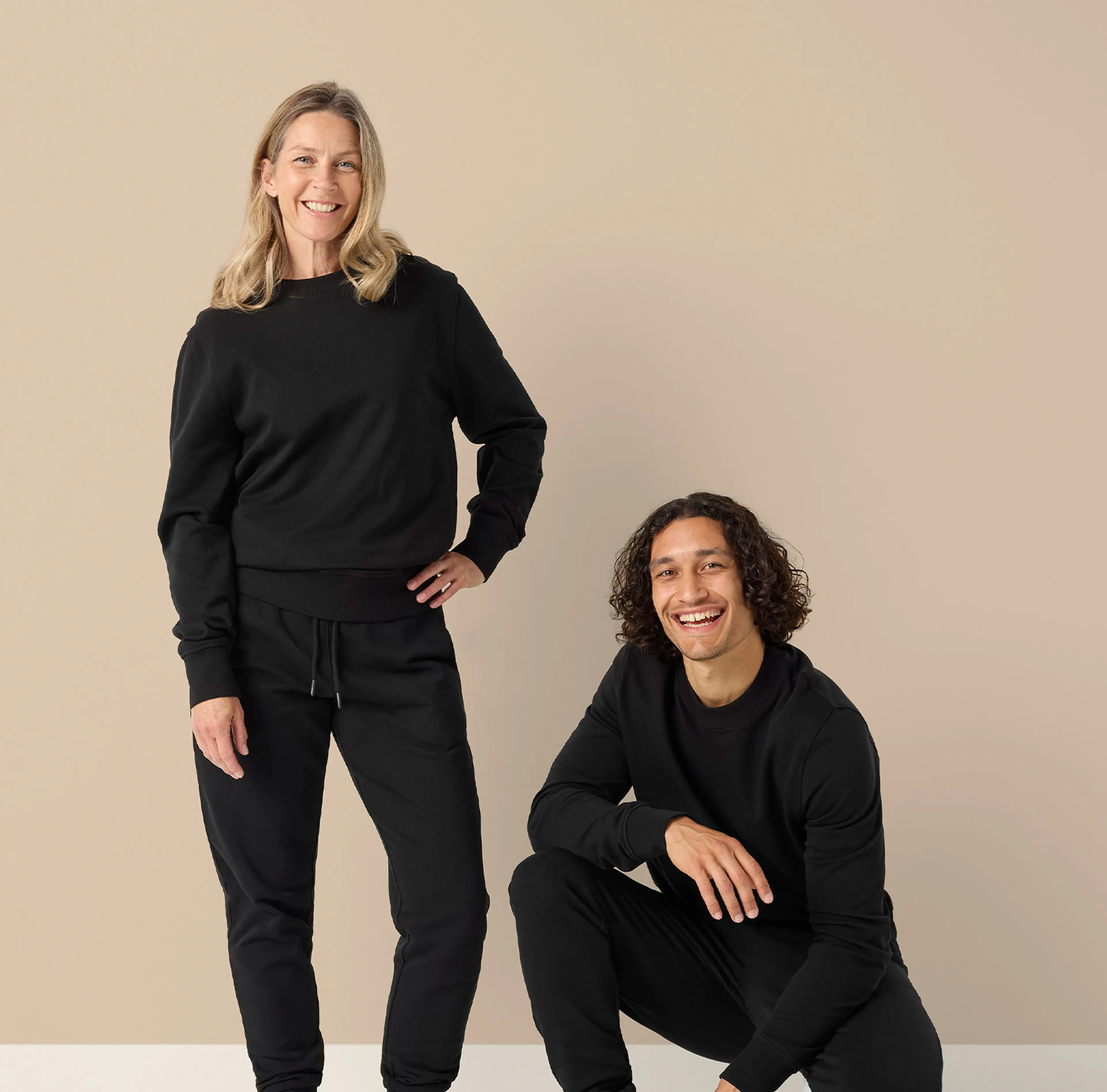 Svart sweatshirt och matchande mjukisbyxor i en enkel, bekväm design för dam och herr. Mjuka ribbade muddar och rund halsringning ger en avslappnad look.