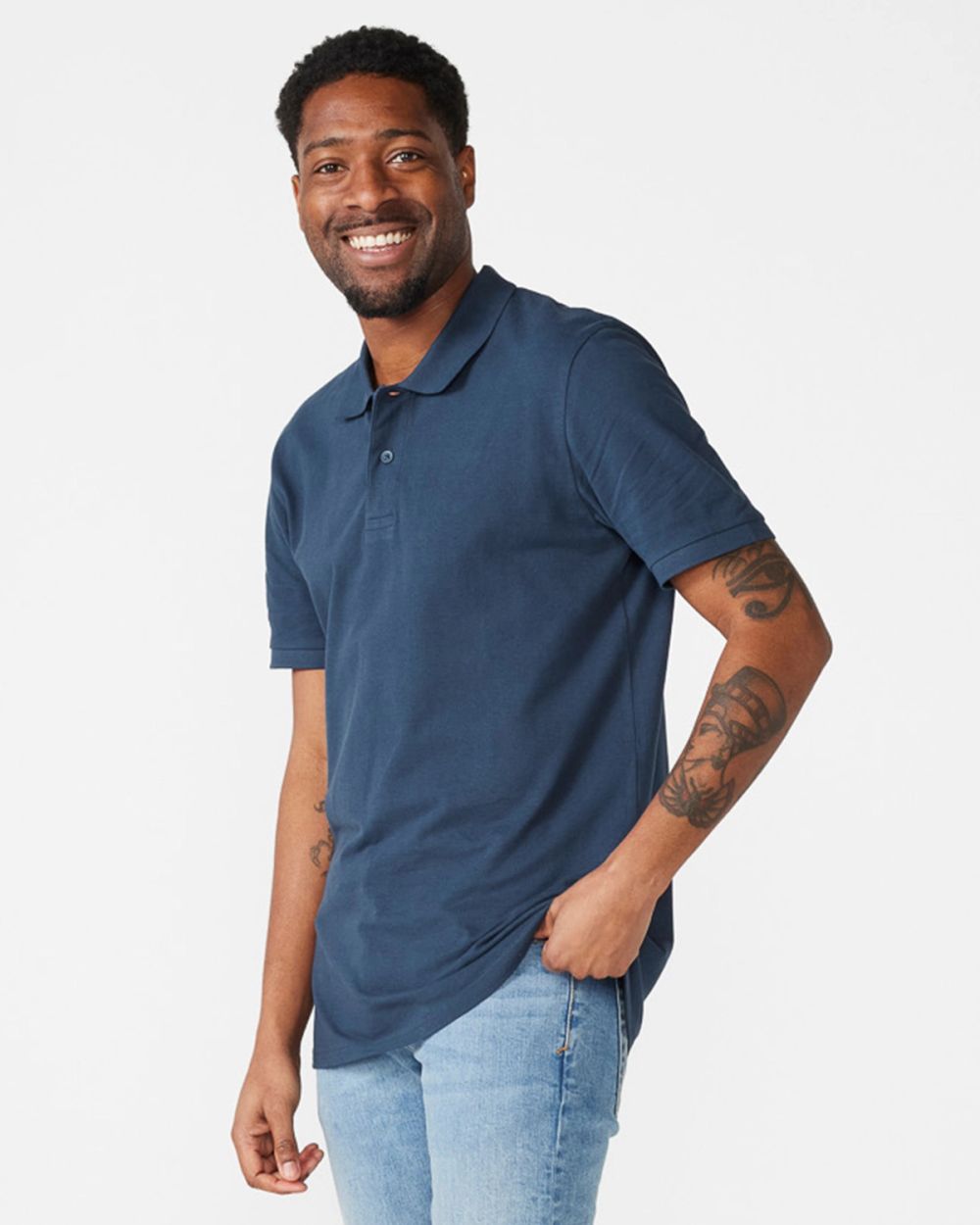 En lättstickad pique-shirt i mörkblått med kort ärm och krage, modellburen av en leende person. Matchas fint med ljusa jeans för en avslappnad look.