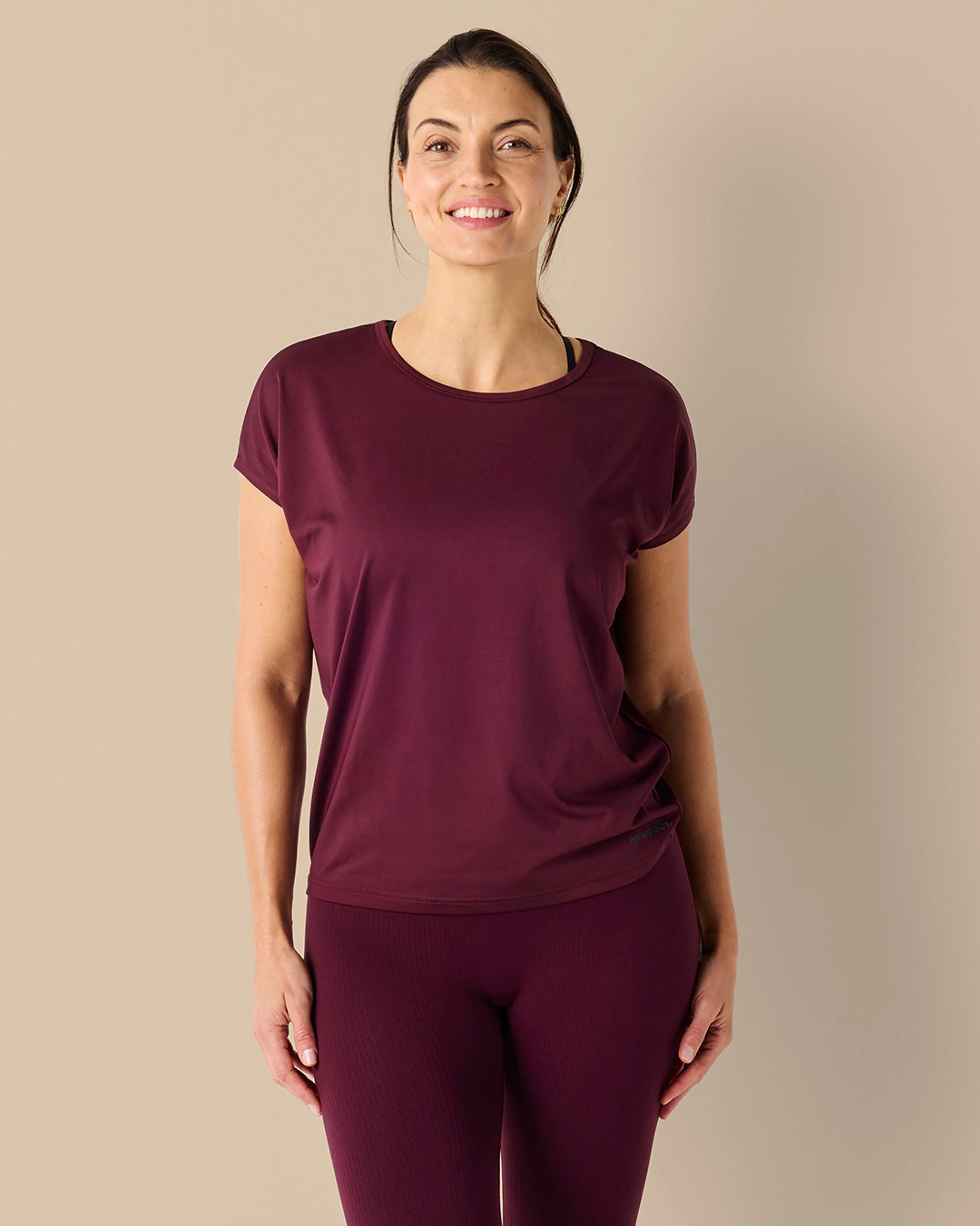 Kvinna bär vinröd tränings t-shirt