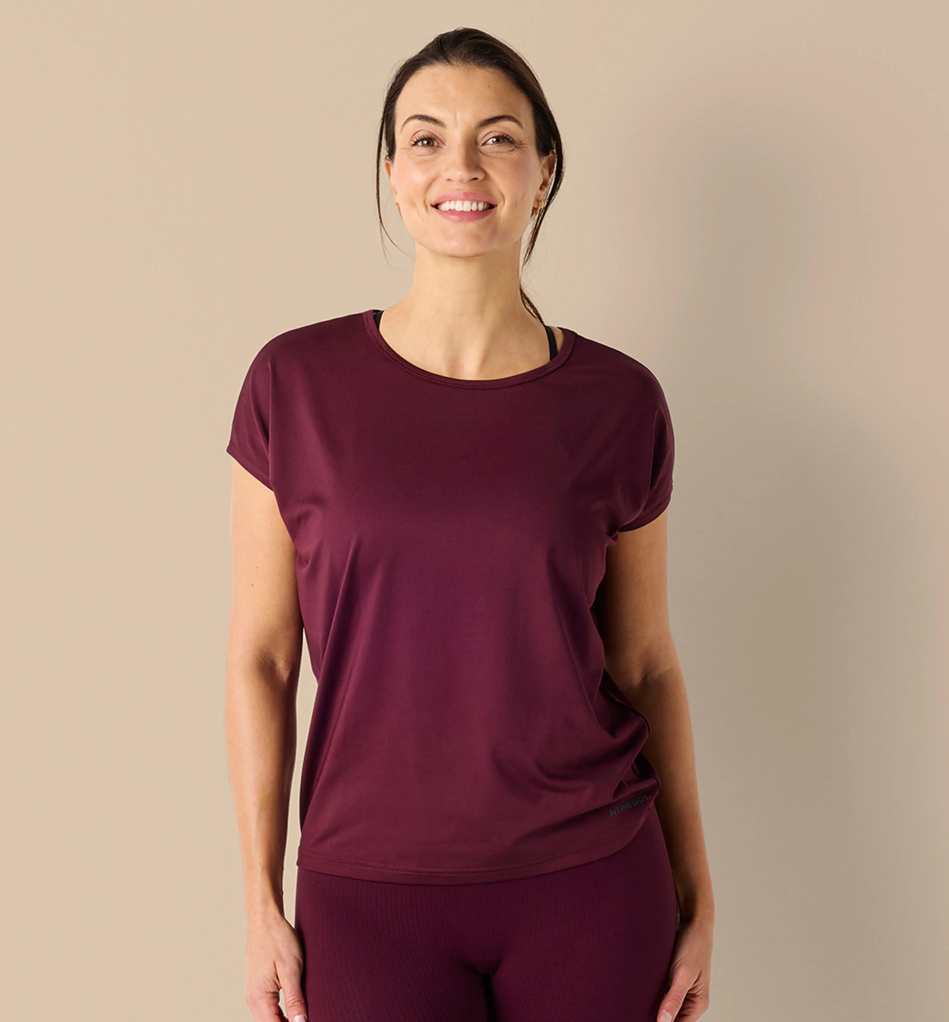 Kvinna bär vinröd tränings t-shirt