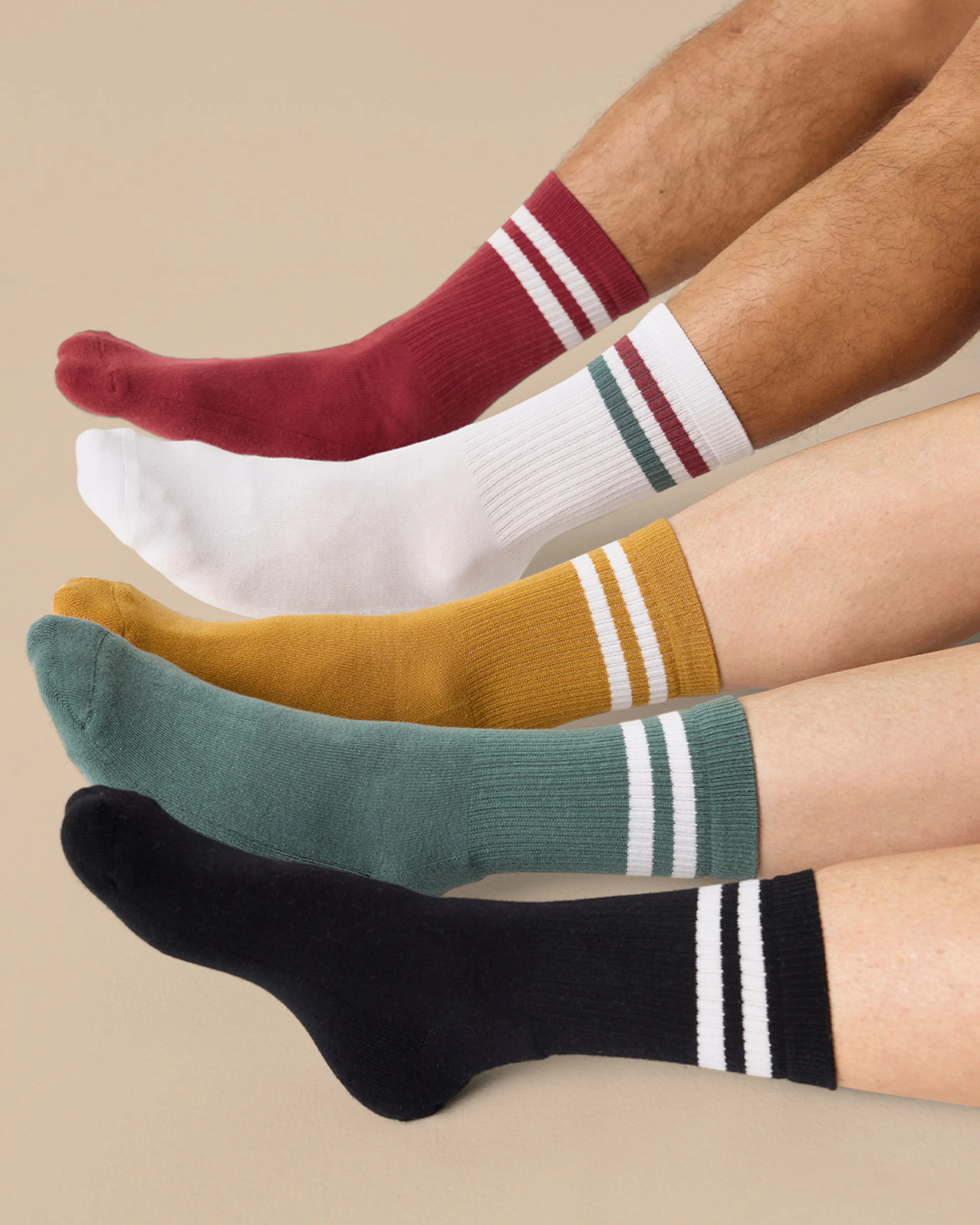 Fem par sportstrumpor i olika färger med ribbad struktur och två ränder vid öppningen, i rött, vitt, senapsgult, grönt och svart.