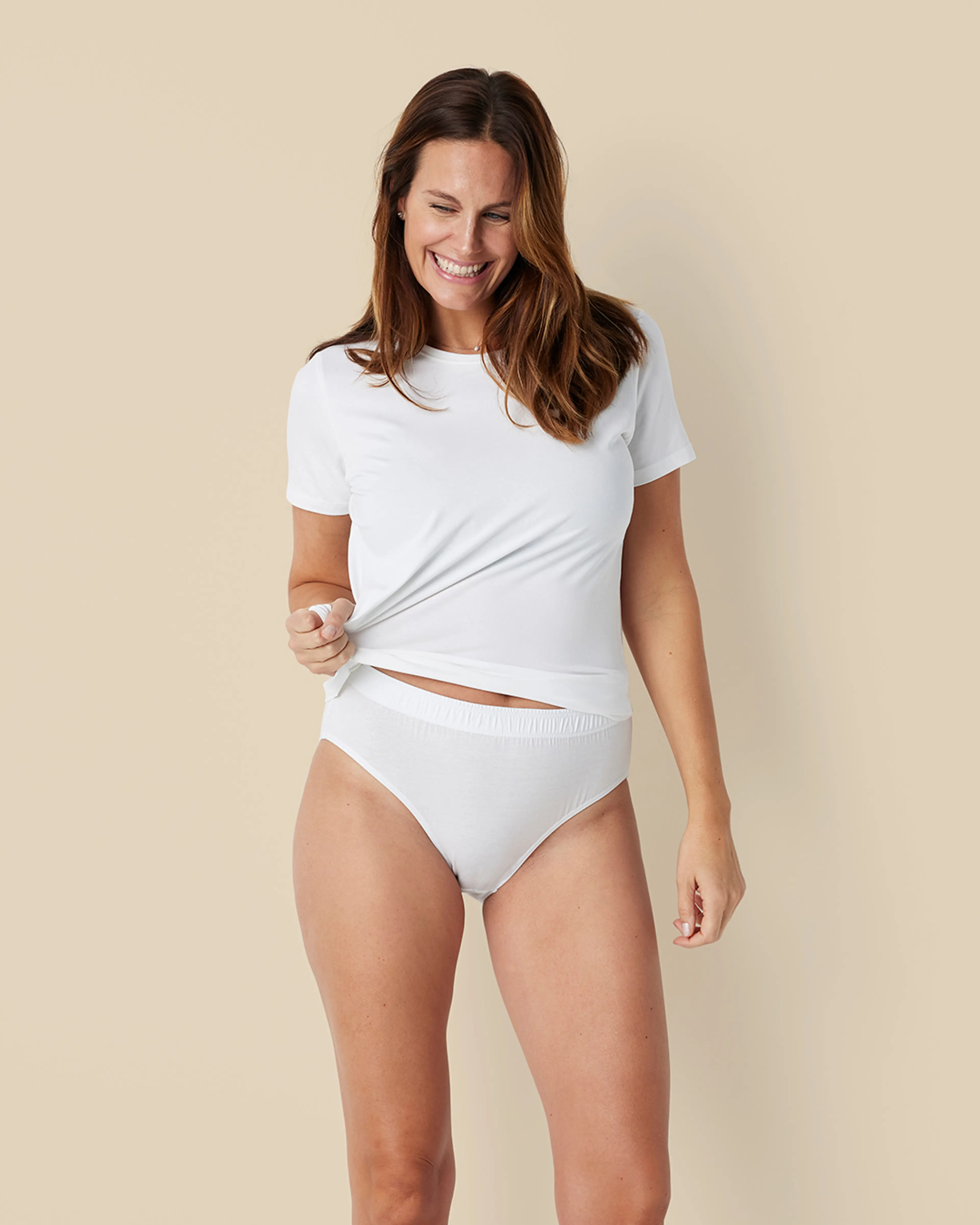 En mjuk vit kortärmad t-shirt i ekologisk bomull tillsammans med ett par enkla vita bomulls-trosor med resår i midjan.