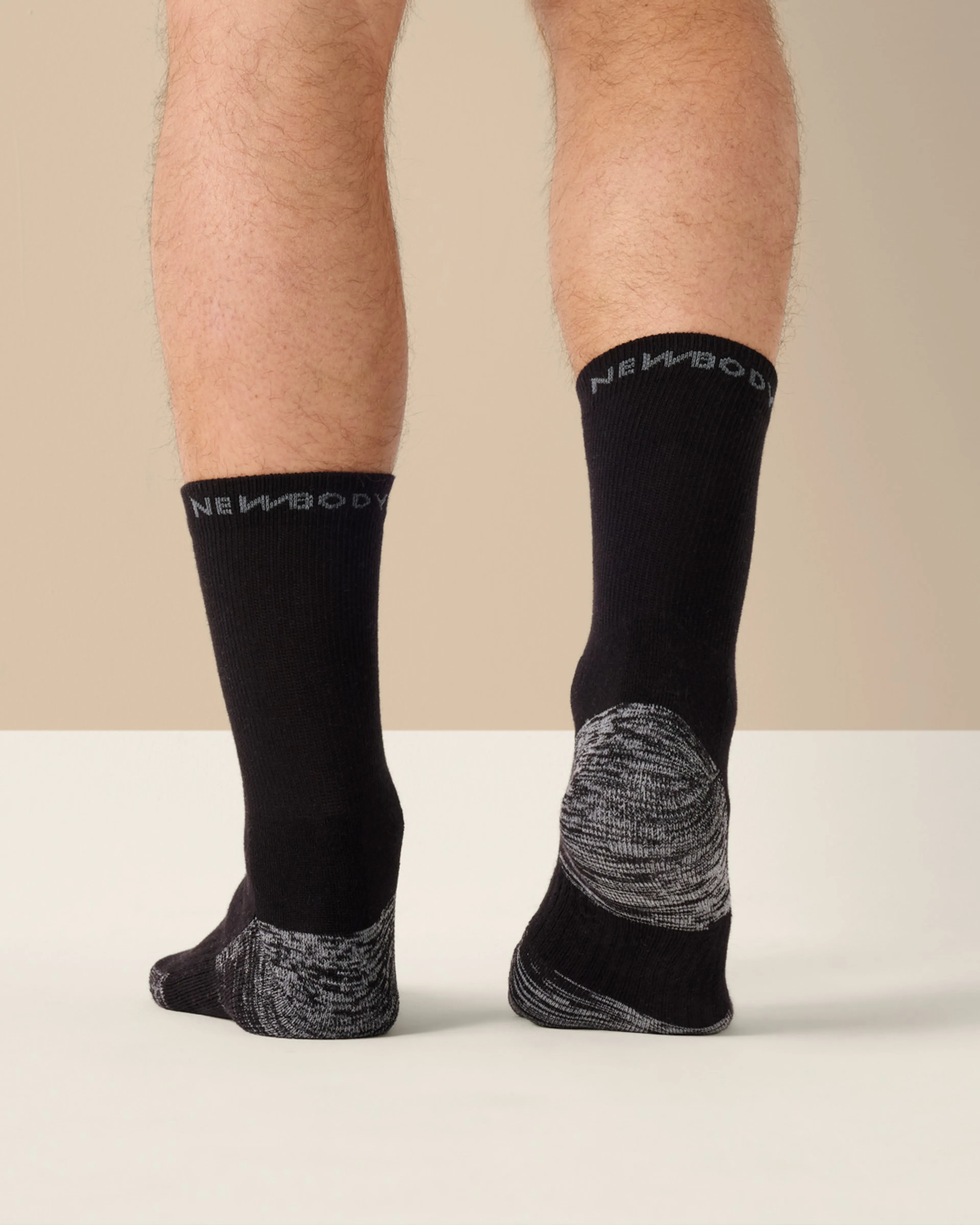 Svarta strumpor med grå mönstrad häl och tå, mjuk och bekväm passform. Strumporna är längre och har en enkel design med text på skaftet.
