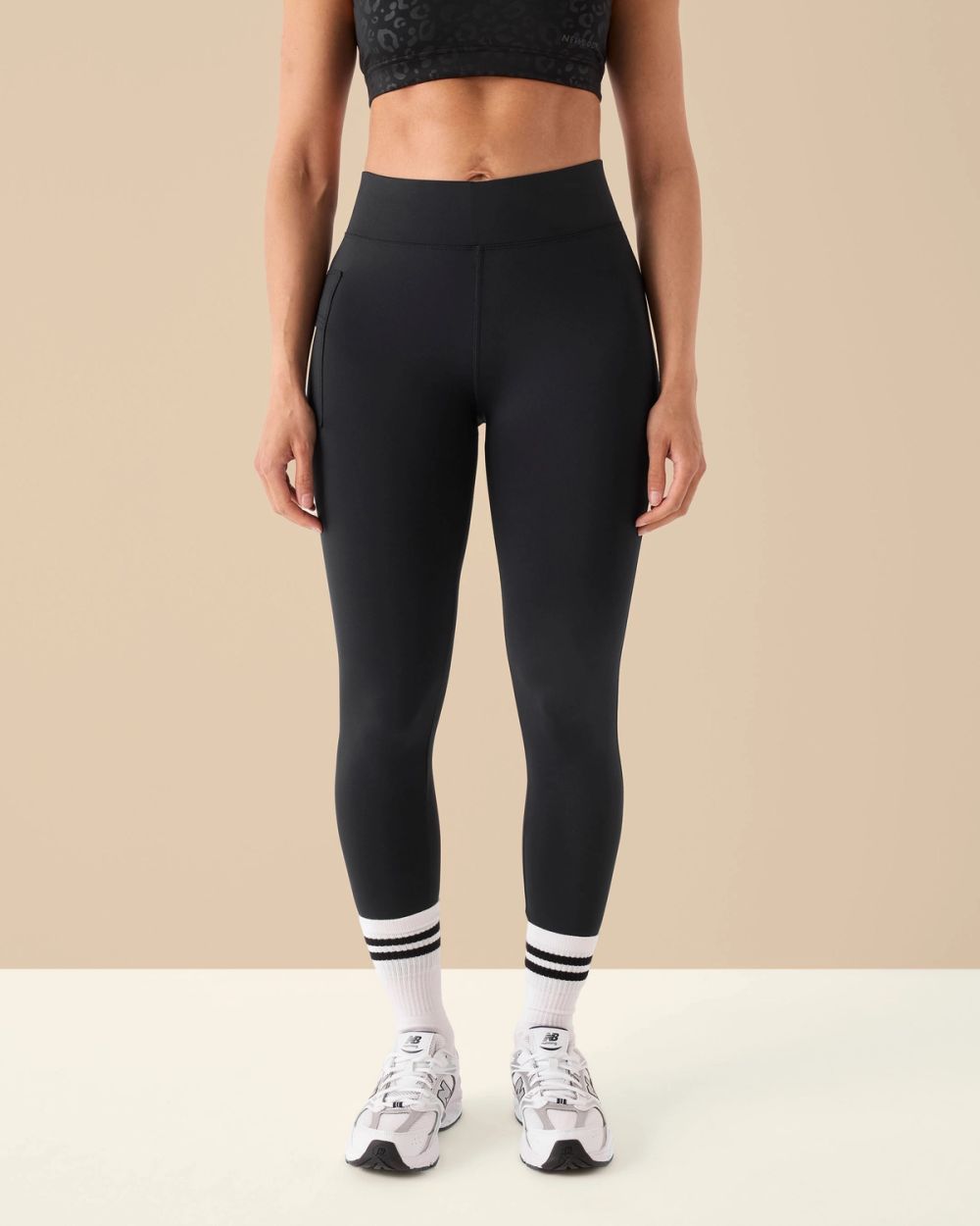 Kvinnlig modell i svarta Performance Tights sedda framifrån.