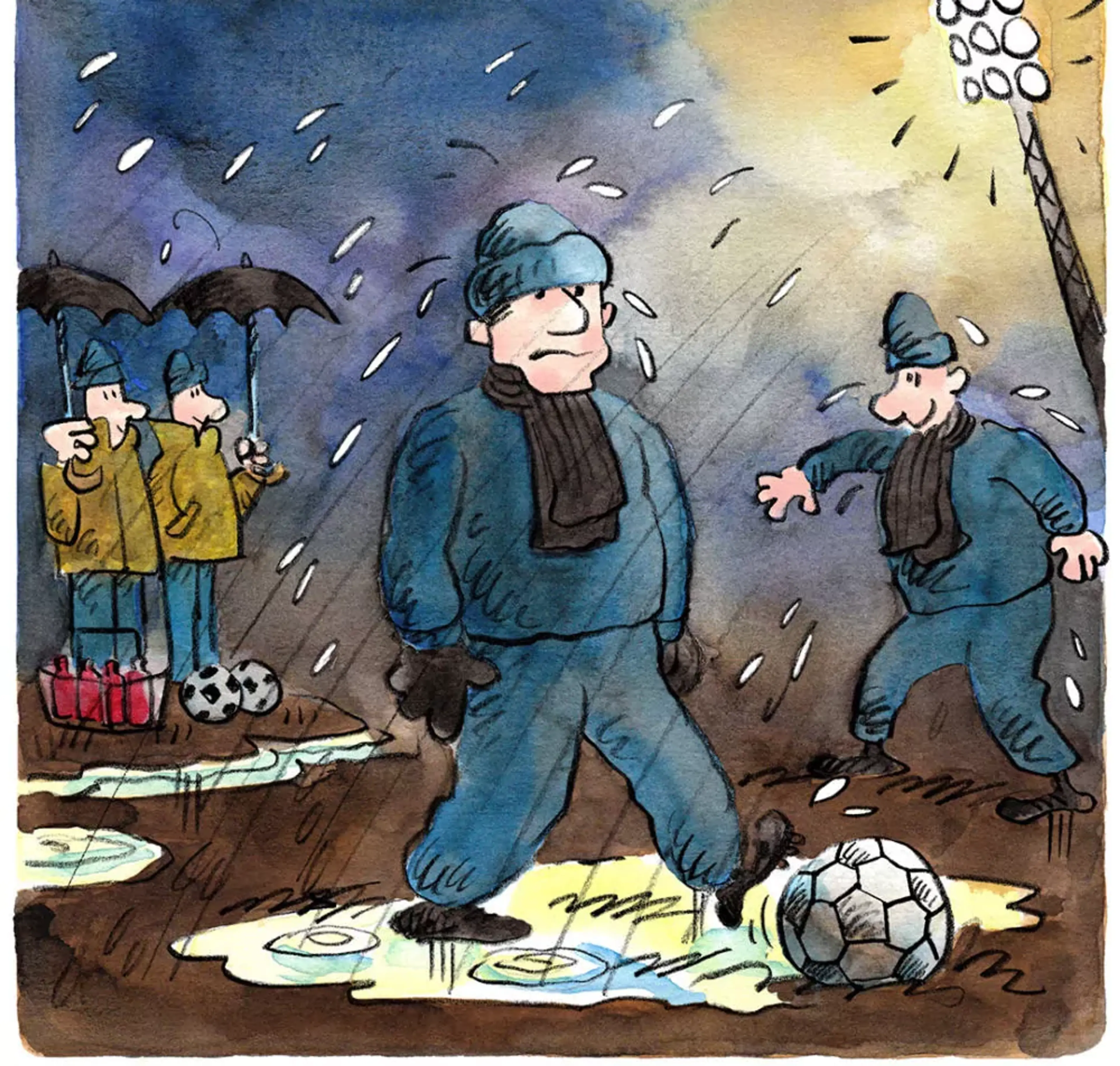 Två personer i varma kläder spelar fotboll i regn på en lerig plan under starka strålkastare, medan två personer med paraplyer och vattenflaskor står vid sidan om. Mörka moln och regndroppar fyller himlen