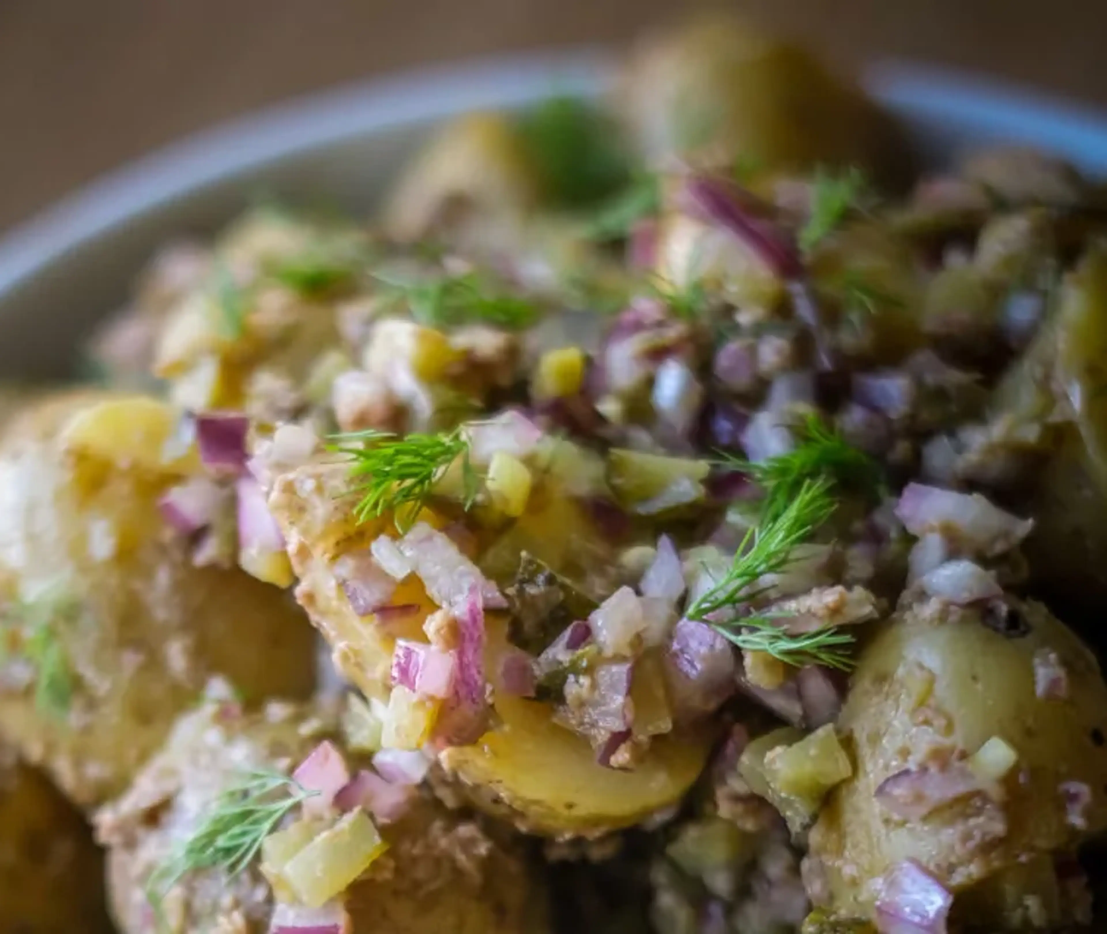 Potatissallad med små, skalade delikatesspotatisar blandade med finhackad rödlök och dill. En enkel och fräsch sommarrätt.