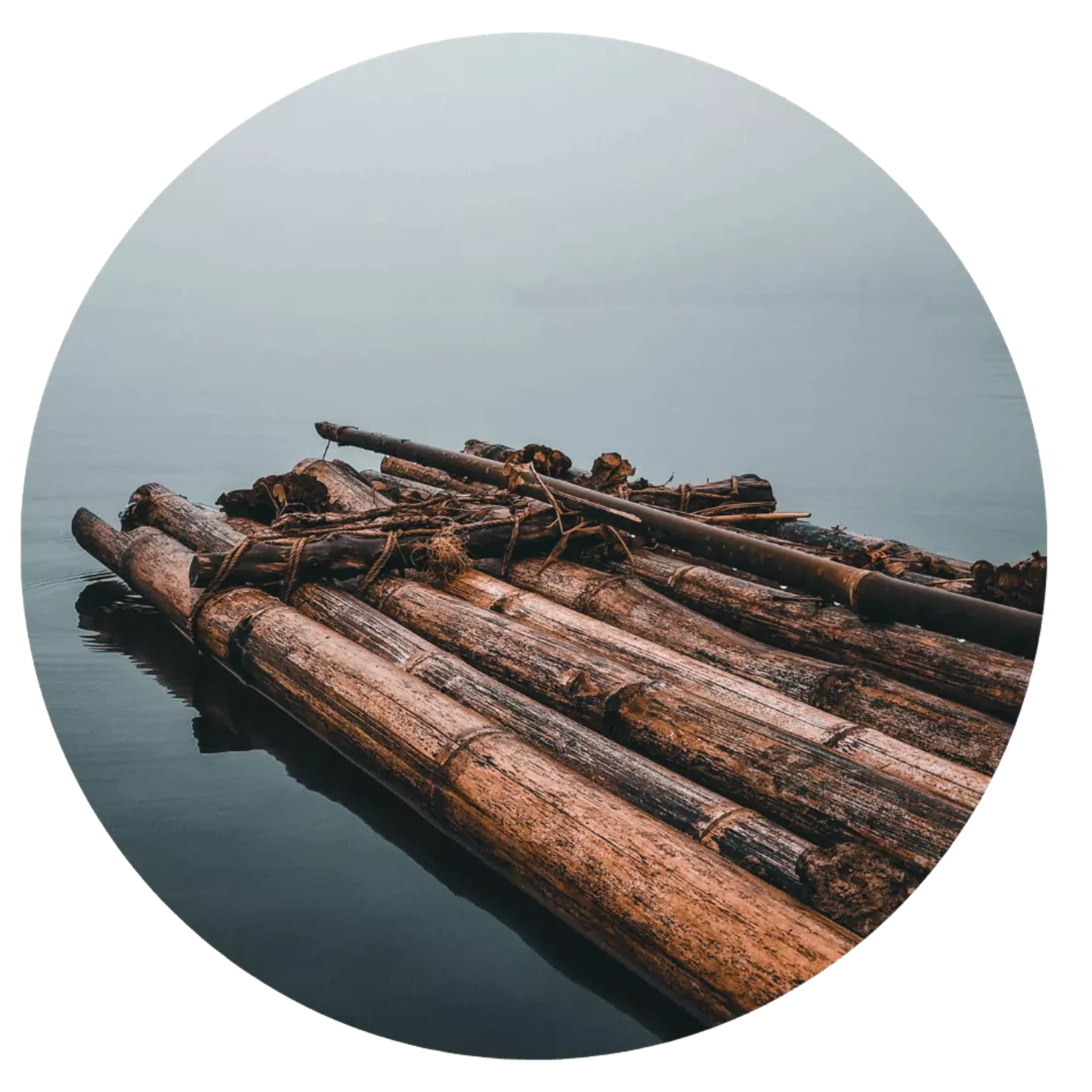 En enkel flotte byggd av grova timmerstockar som flyter stilla på lugn vattenyta. En lång åra vilar ovanpå flottens träbjälkar.