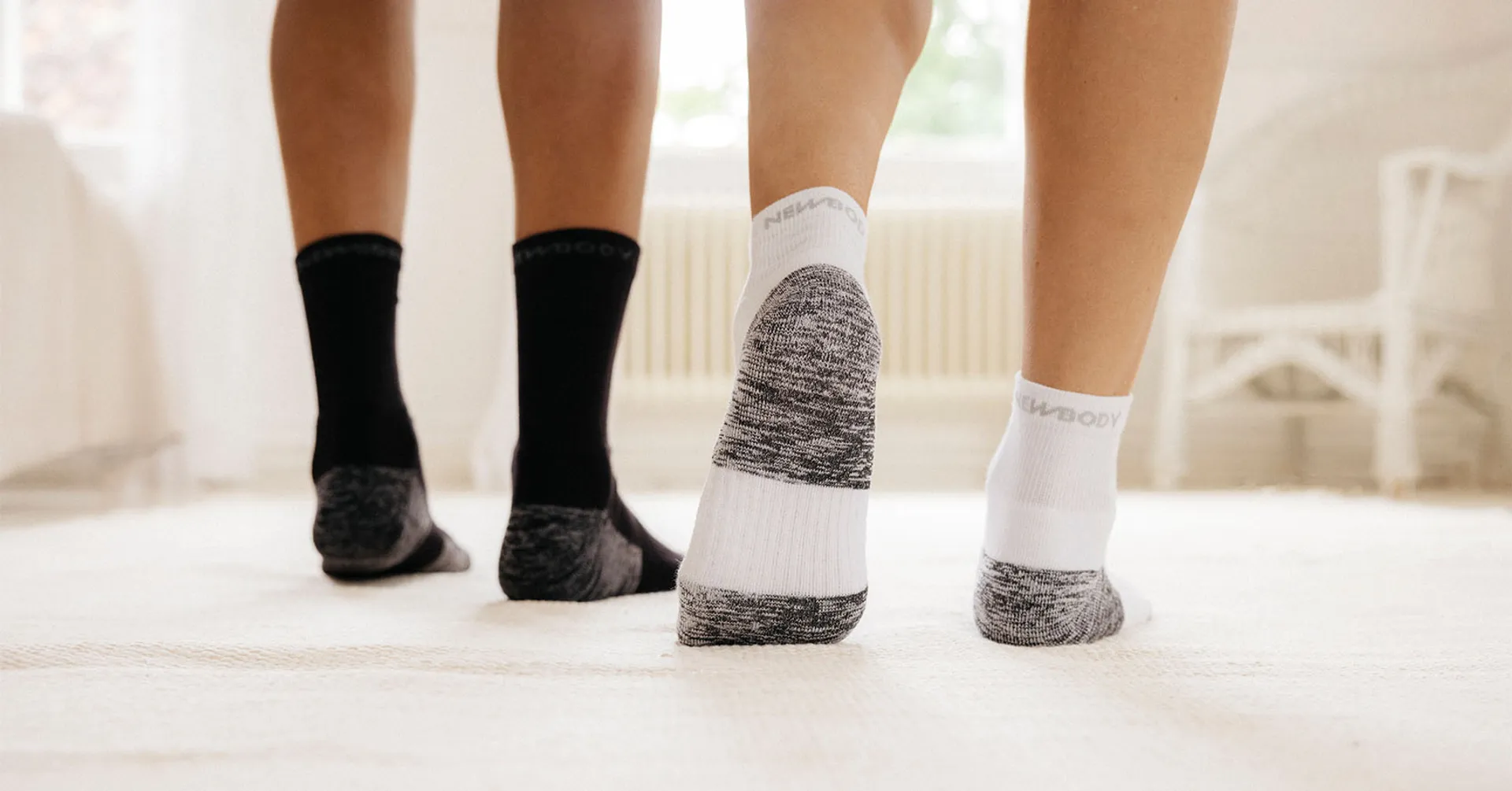 Två par strumpor i svart och vitt med mönstrad häl och tå, i en ribbad och mjuk design som sitter lagom högt på vristerna.