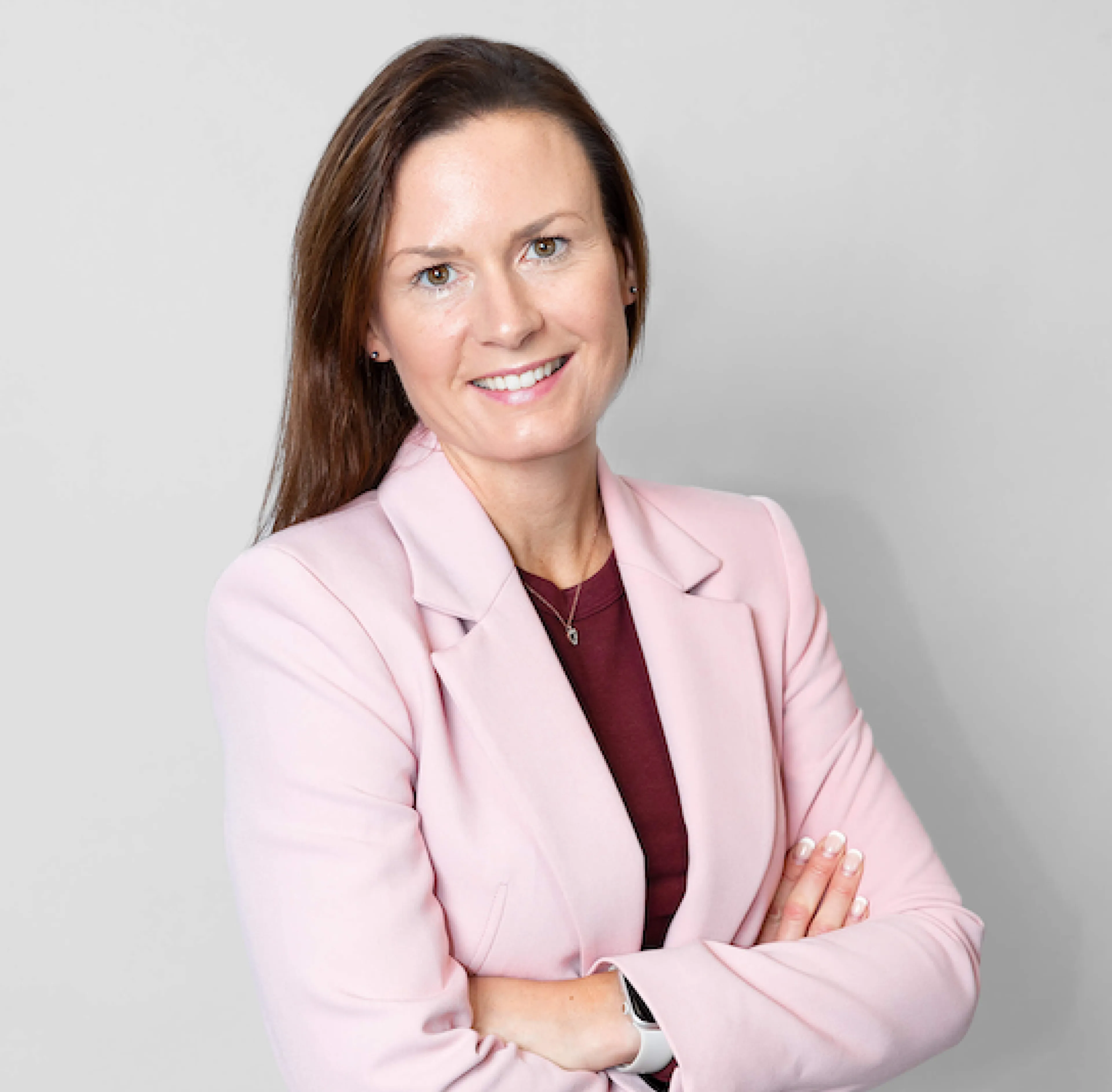 Kvinna i ljusrosa kavaj och brunt hår