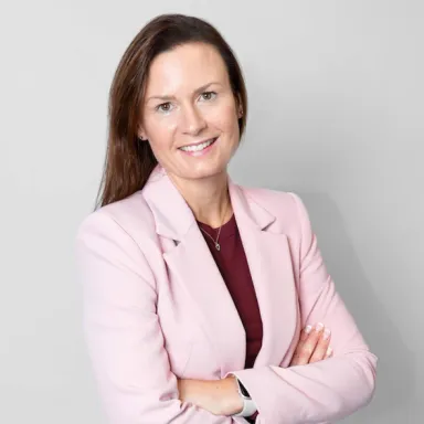 Kvinna i ljusrosa kavaj och brunt hår