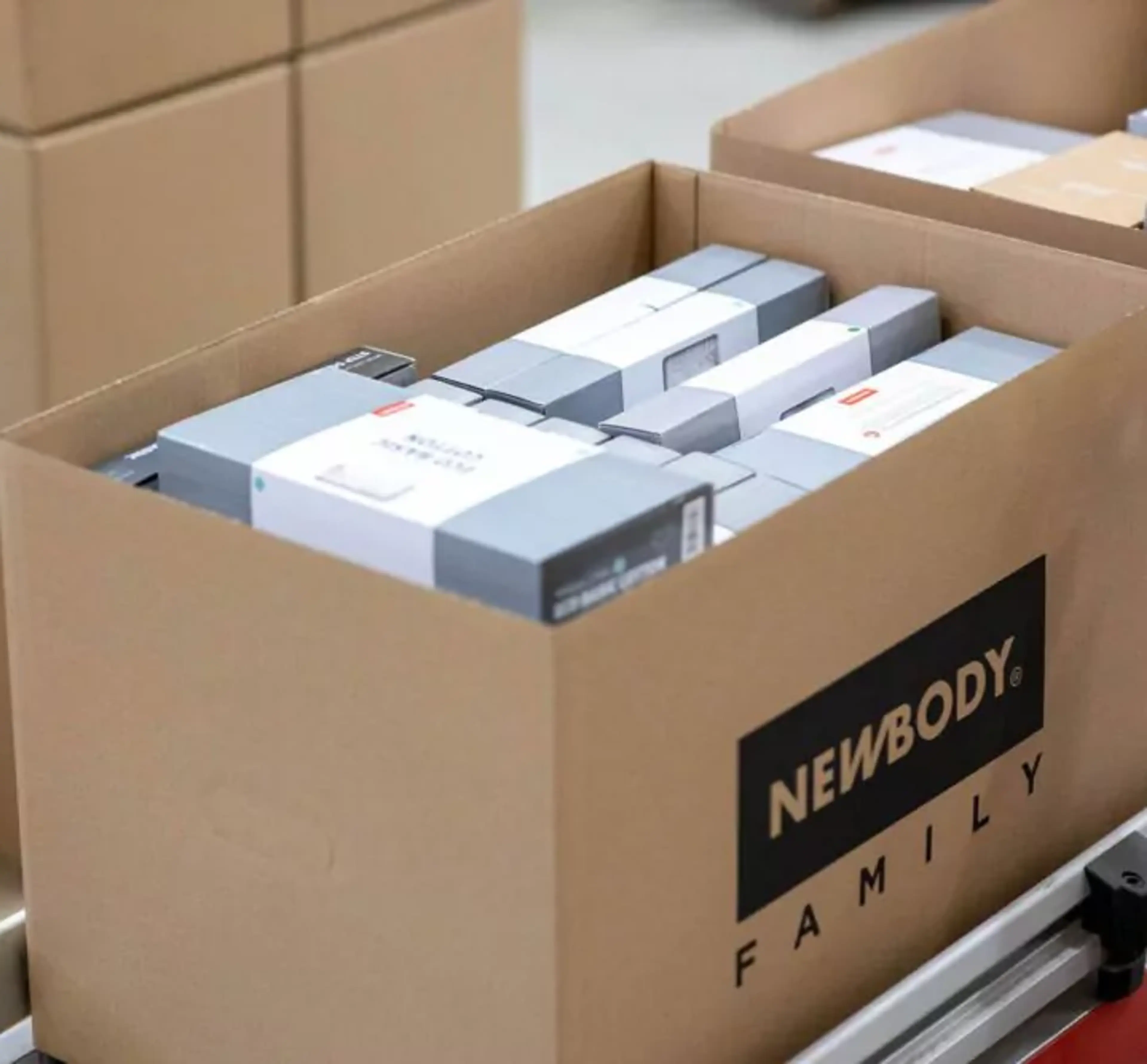 En öppen kartong fylld med prydligt paketerade produkter i olika storlekar, redo för leverans. Kartongen står på en pall tillsammans med andra liknande lådor.