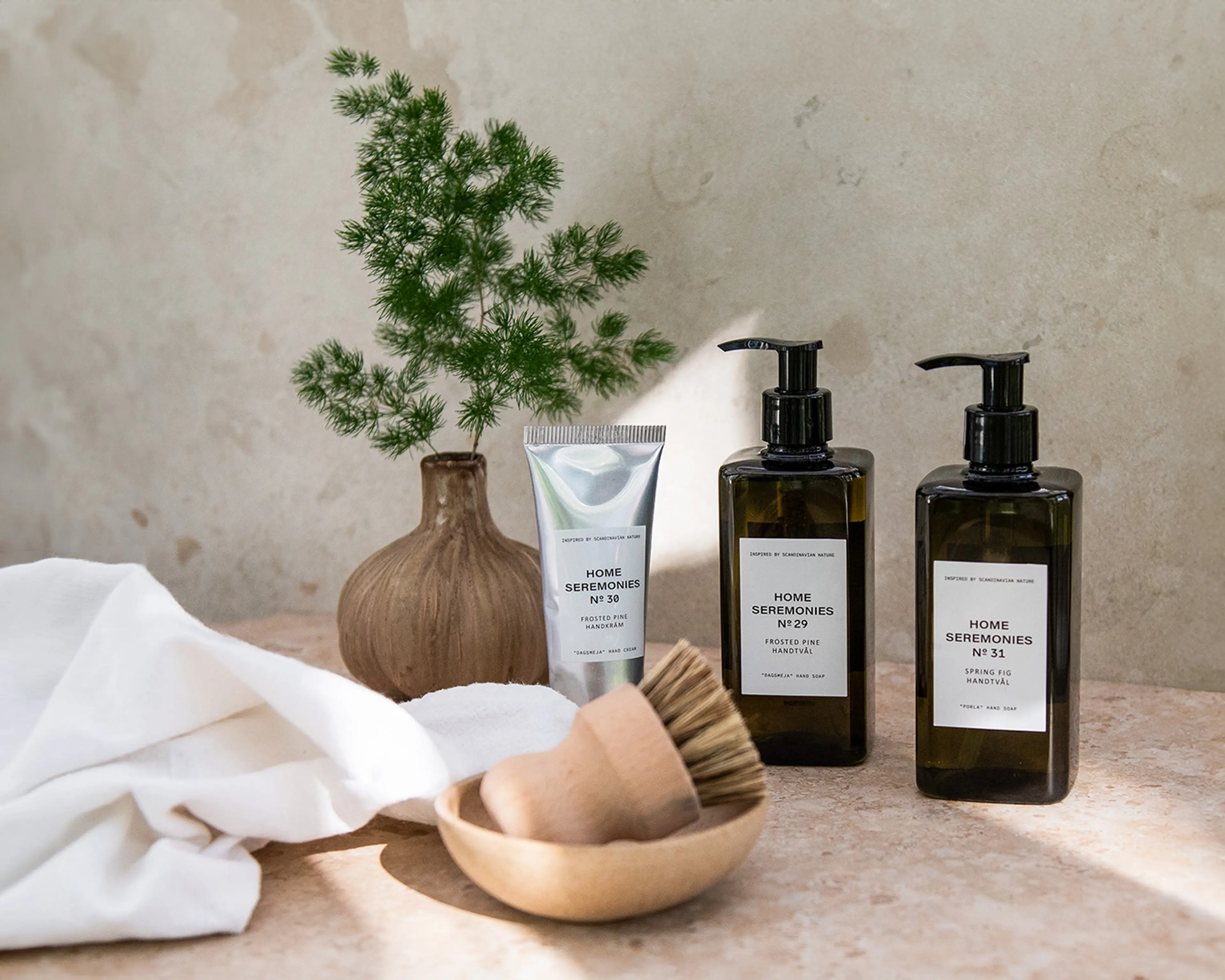 Två flaskor med handtvål och en tub handkräm i en inspirerande miljö