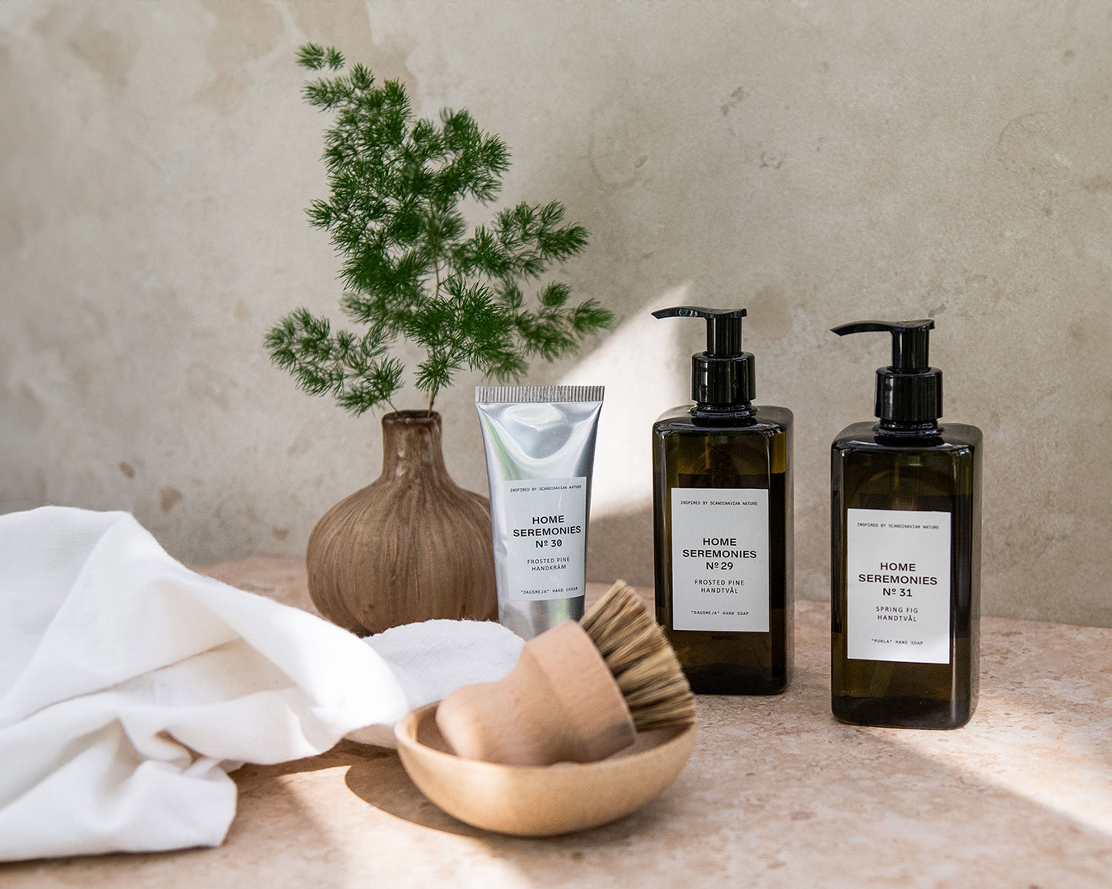 Två flaskor med handtvål och en tub handkräm i en inspirerande miljö