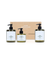 Tre flaskor med body wash och body lotion i gröna pumpflaskor framför en enkel kartongförpackning i brunt papper. Etiketterna är vita med svart text i en ren och modern design.