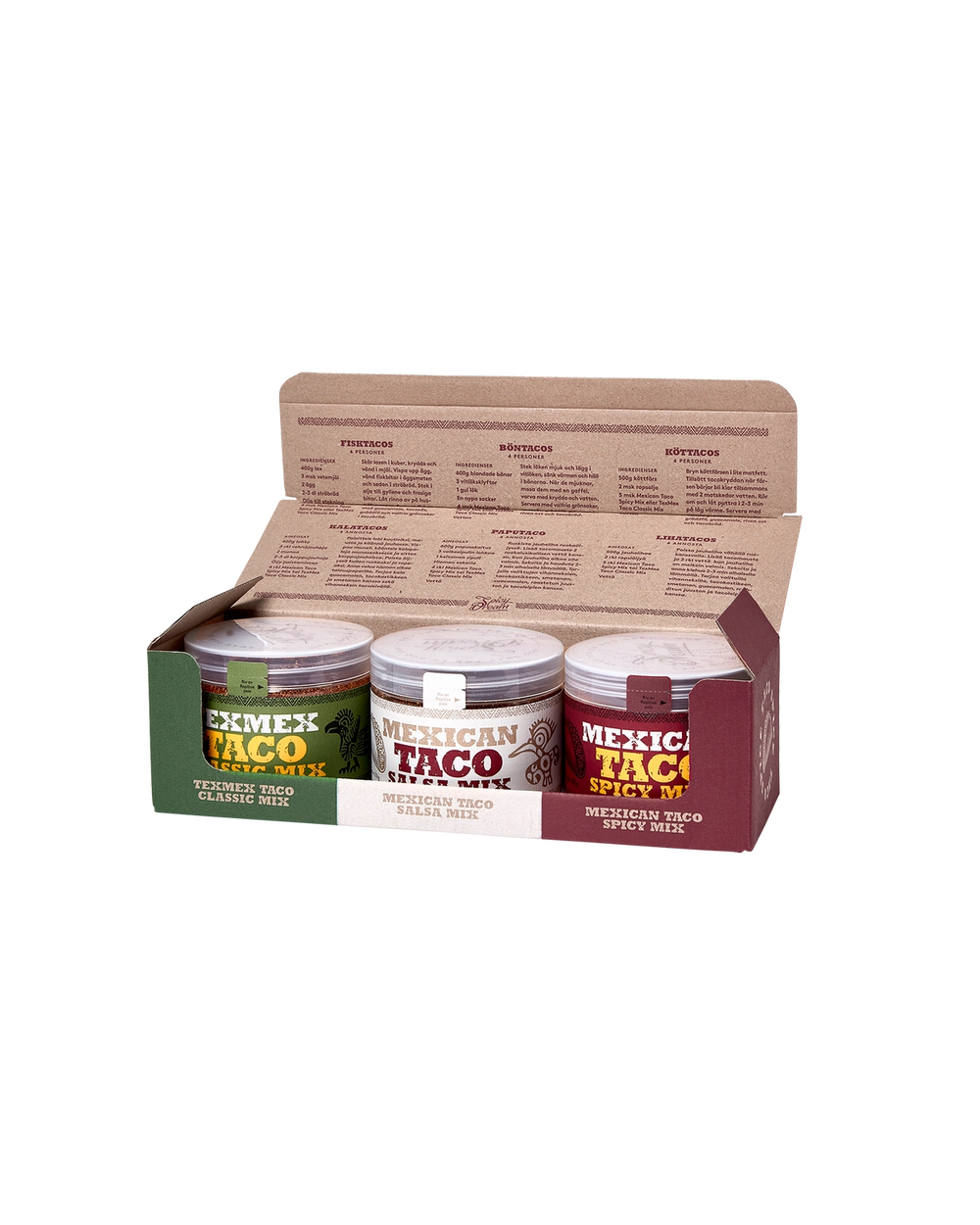 Tre små burkar med olika taco-kryddblandningar i en öppen pappkartong med recept tryckta på insidan av locket. Varje burk har en tydlig etikett i grönt, vitt respektive rött med text och illustrationer.