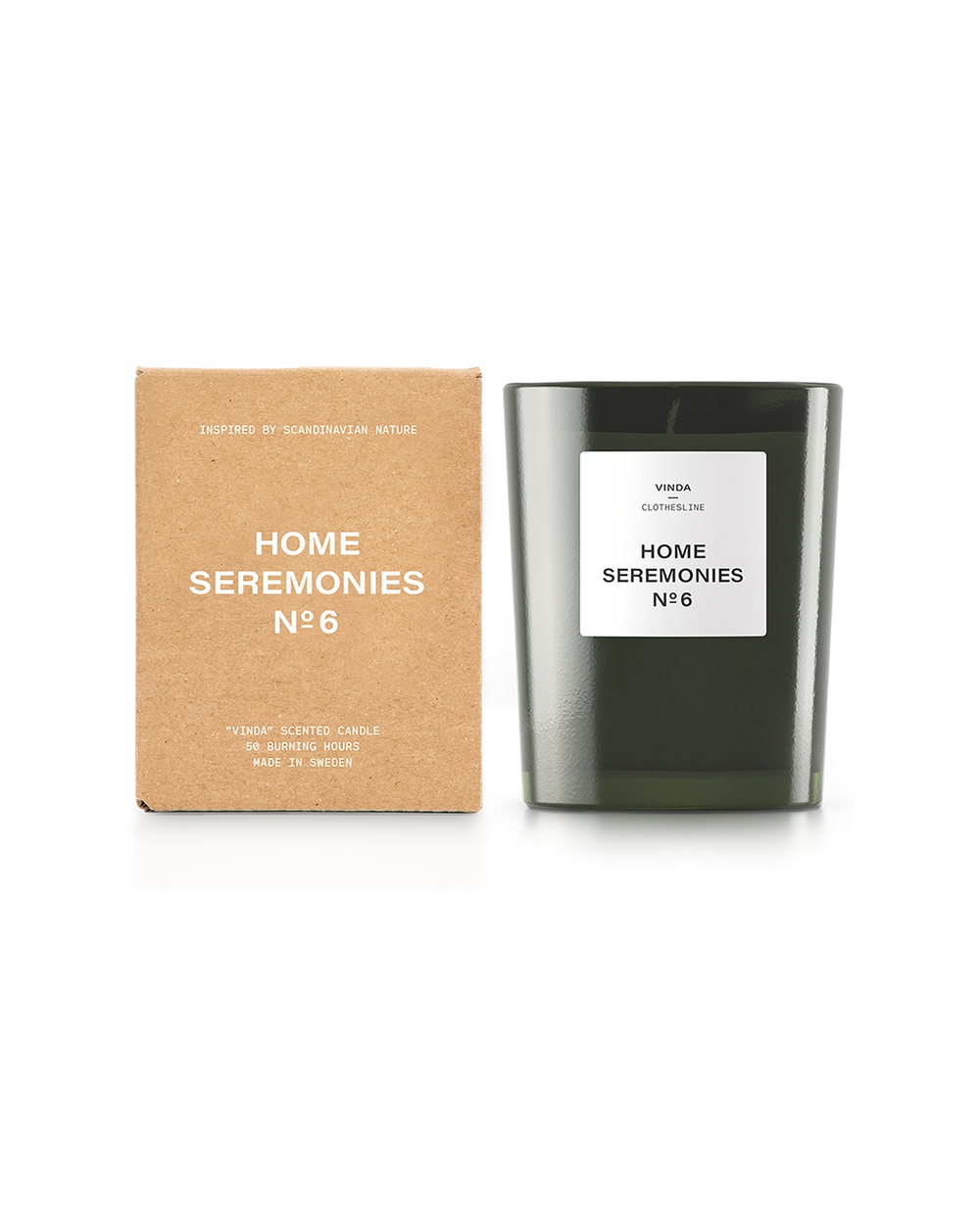 Doftljus i en mörkgrön glasbehållare med vit etikett, tillsammans med dess bruna kartongförpackning med tryckt text. Enkel och stilren design med skandinavisk inspiration.