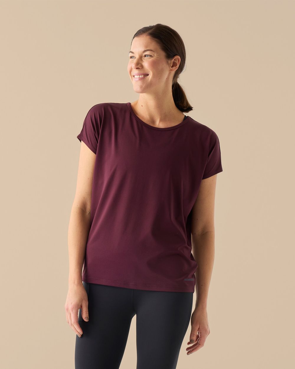 Träningstopp för dam i bordeaux, lös passform, visad på modell framifrån.