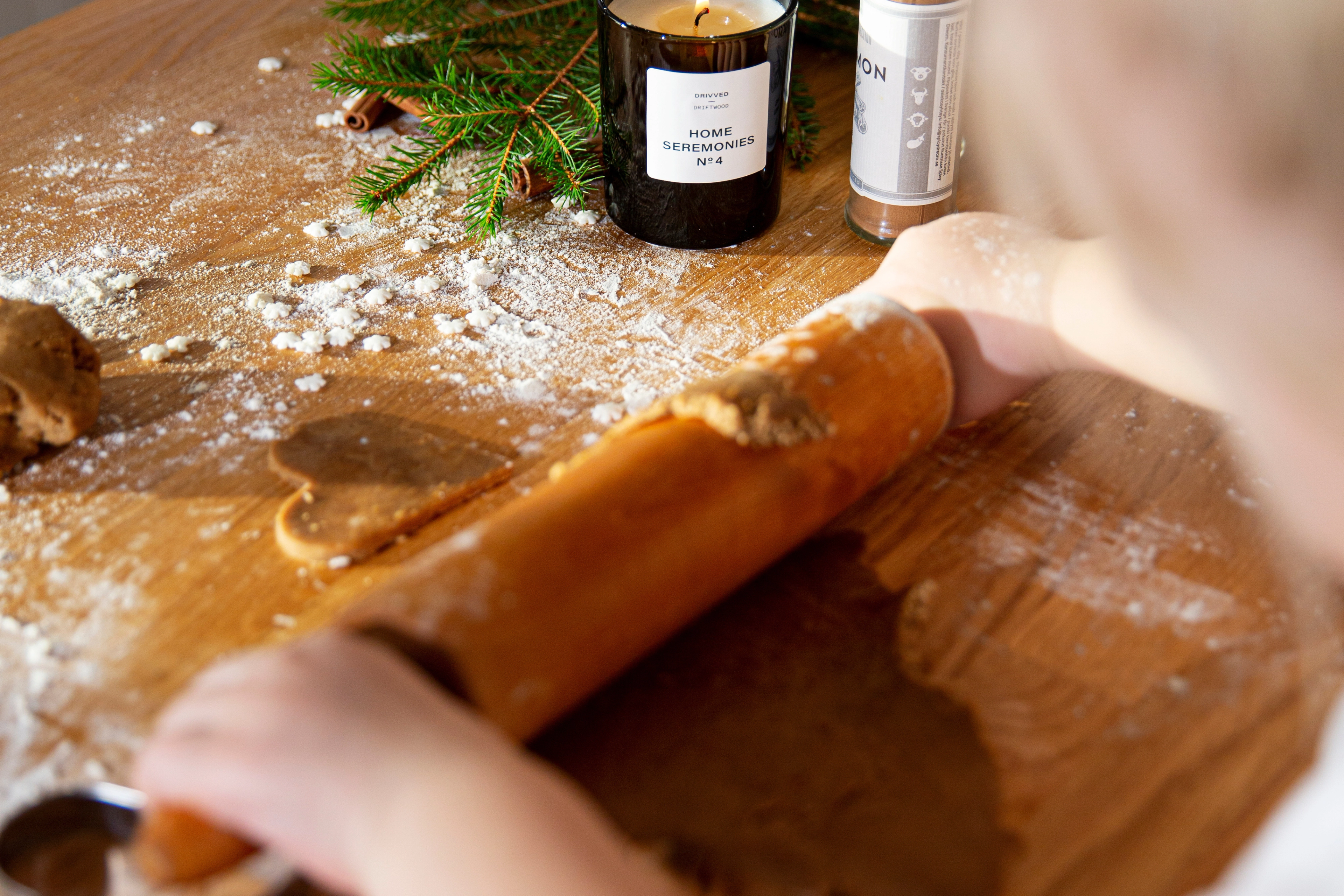 Ett barns armar som kavlar pepparkaksdeg