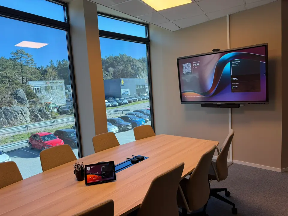 Det nye møterommet hos Digiserv: møtebord med touch-konsoll, dongler og Hisense-touch-TV med Yealink MeetingBar A40 under