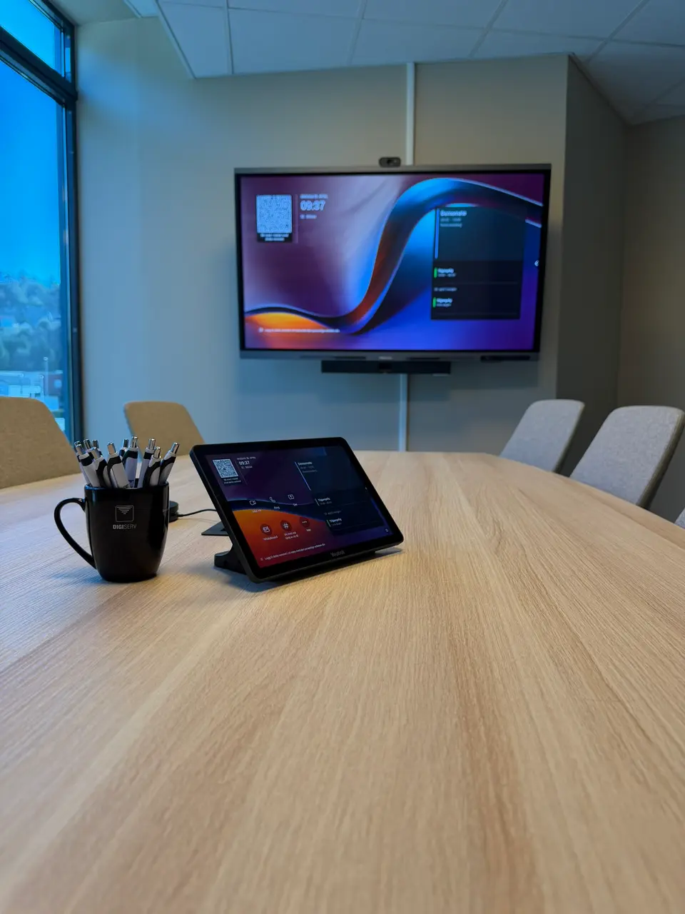 Touch-konsoll på møtebordet, med Hisense-touch-TV i bakgrunnen