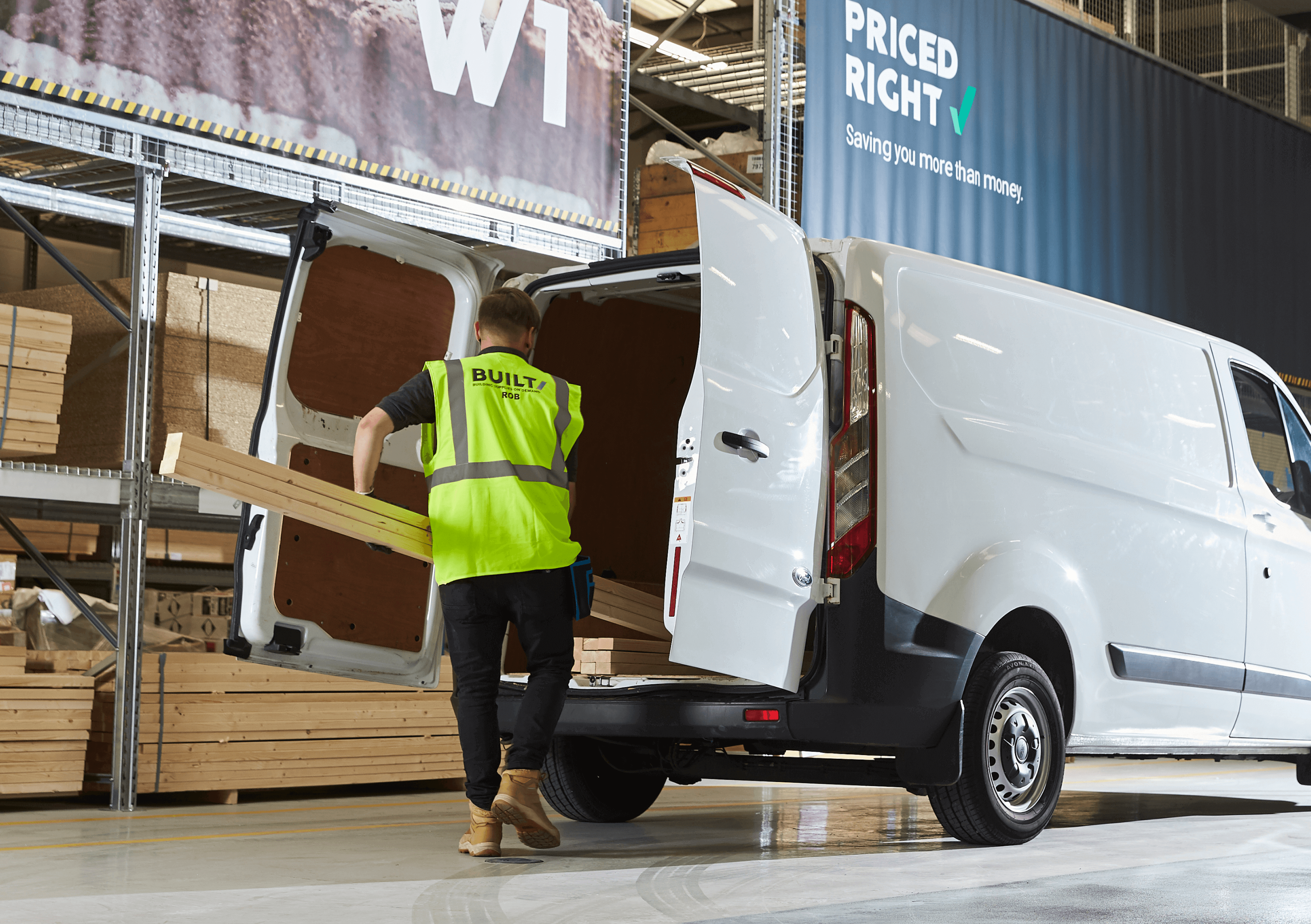 A Built builders merchant specialist loading a delivery van inside a warehouse