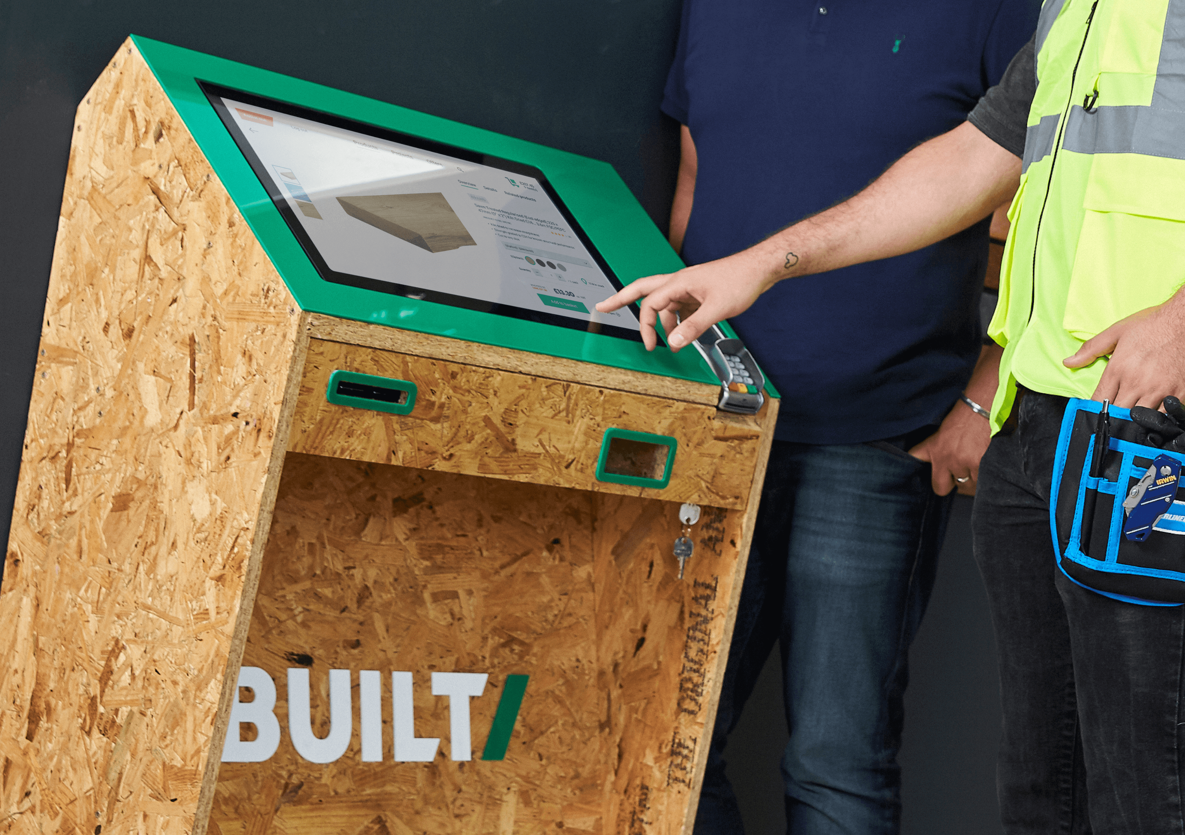 Built builders merchant branded self-service counter being used by two men to purchase a product