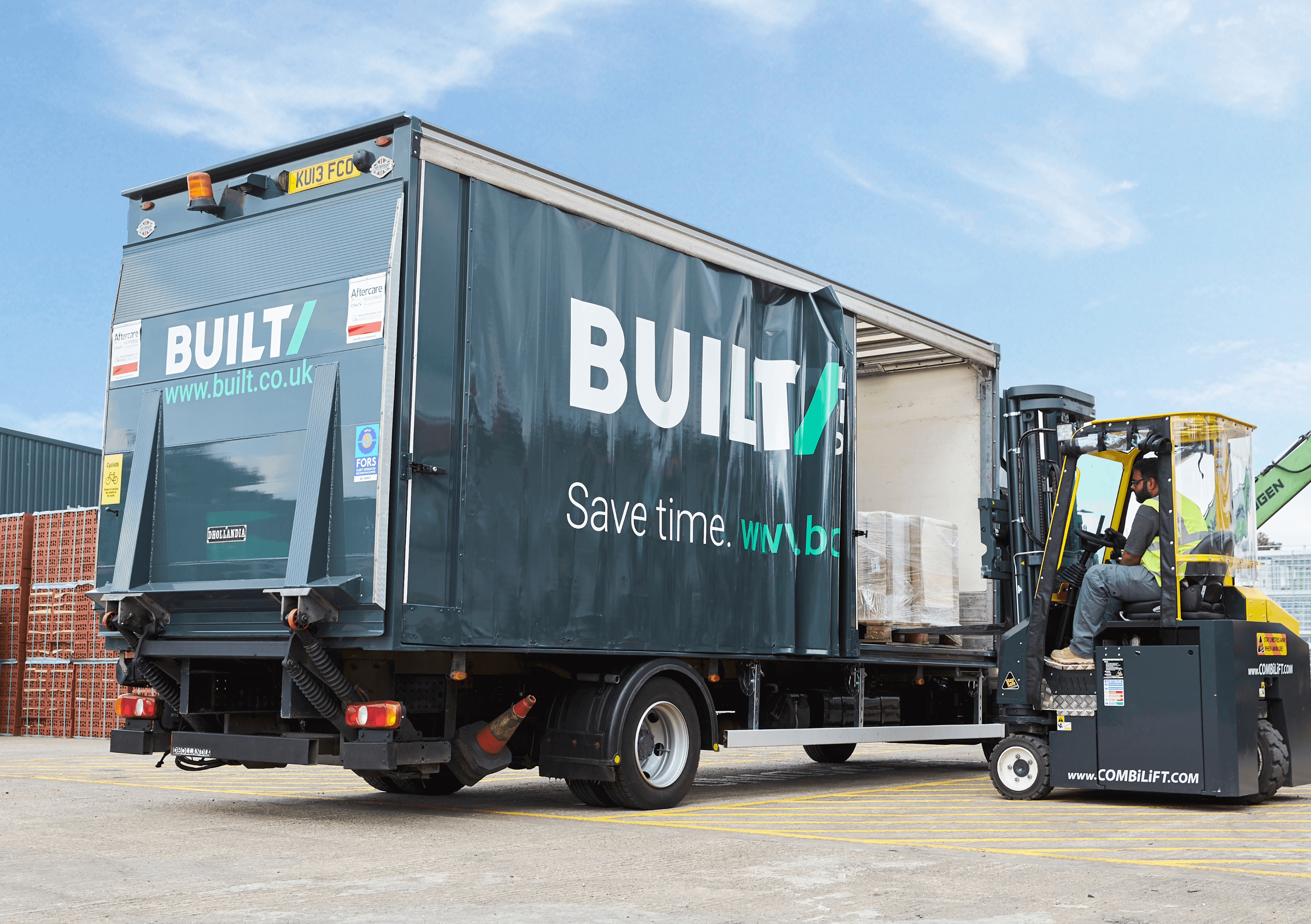 An image showing building supplies being loaded into a lorry with Built branding on the side